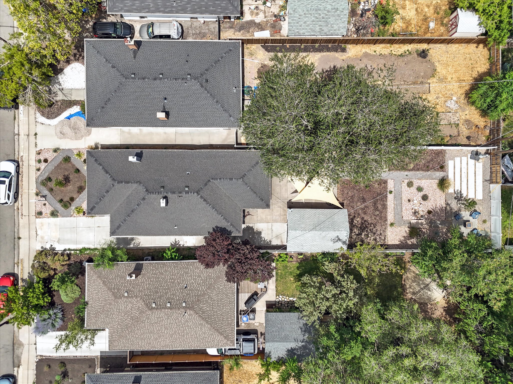 Aerial perspective showcasing two properties with gray shingle roofs and concrete driveways