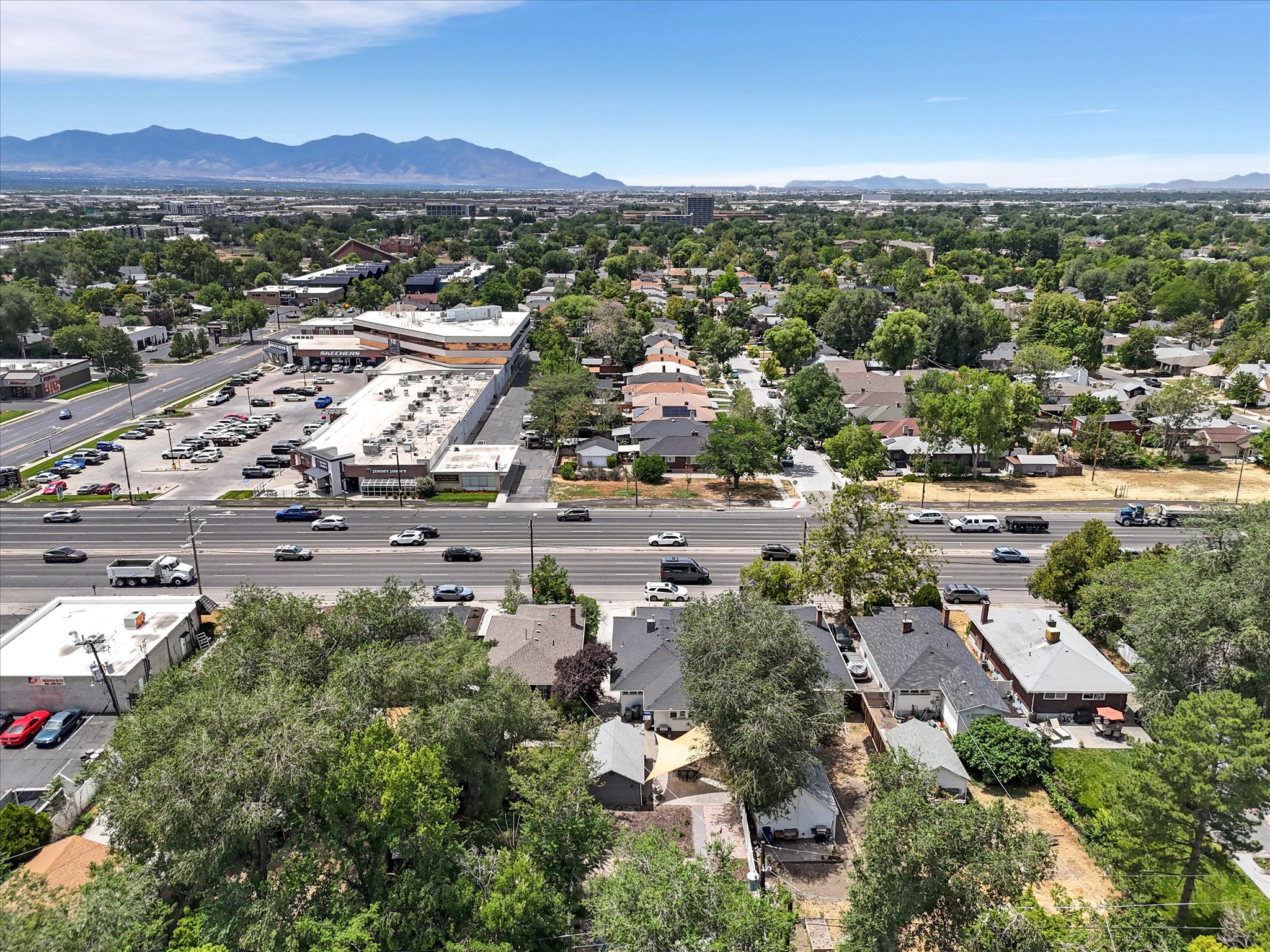 Expansive urban landscape featuring a multi-lane roadway, commercial buildings, and residential properties