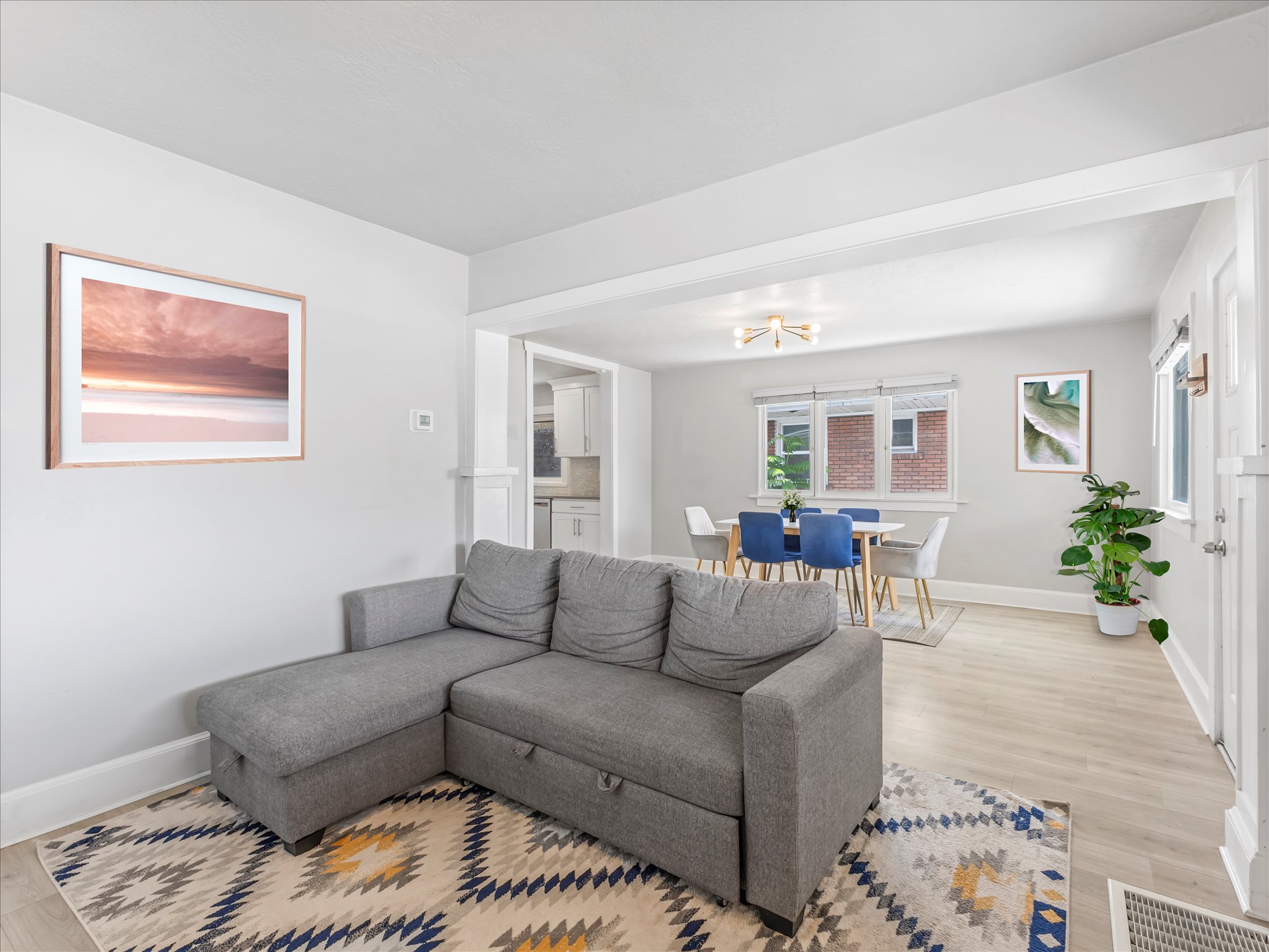 Open-concept living space featuring wood-finish flooring and light-toned wall finishes