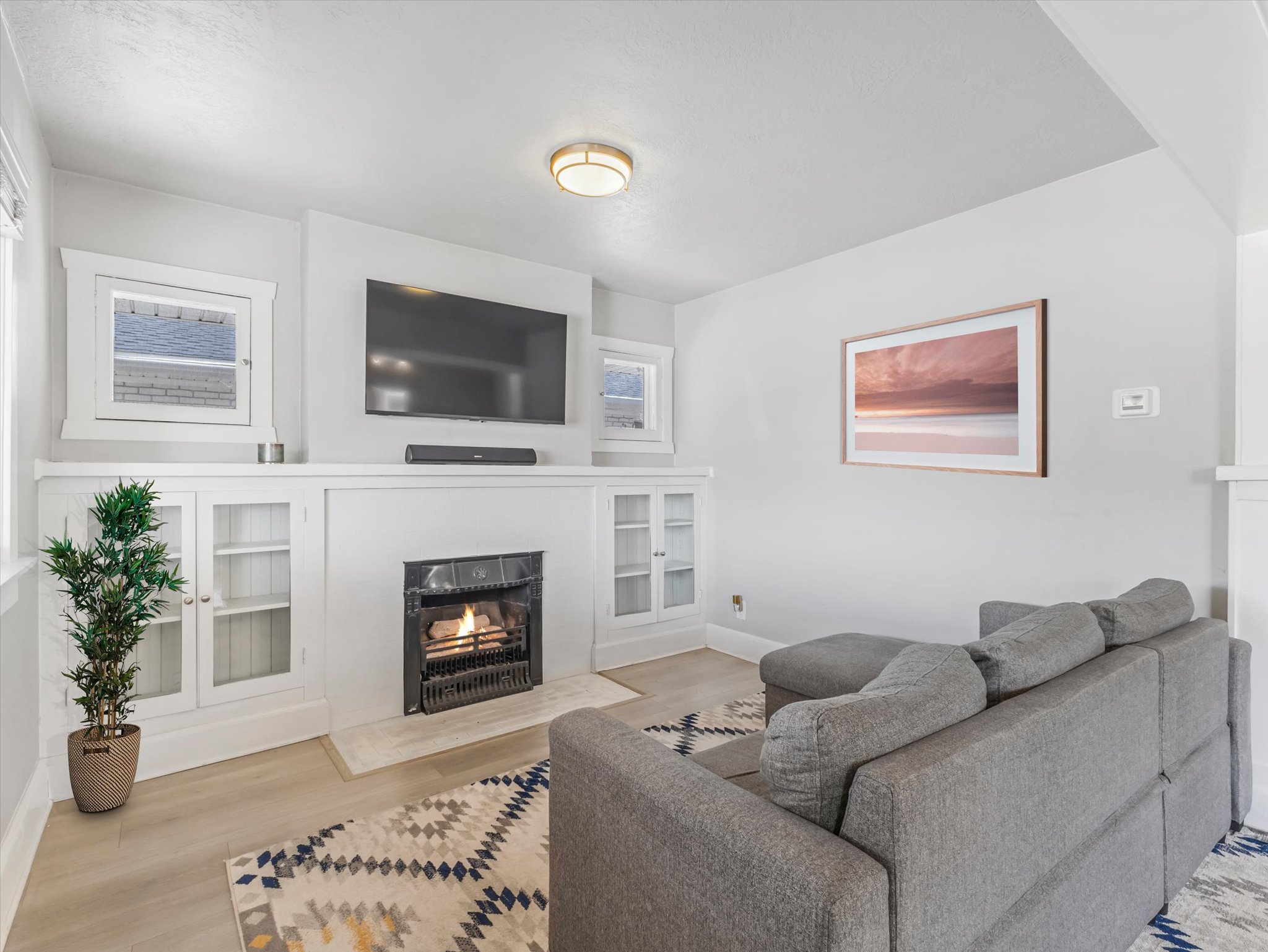 Living area featuring a central fireplace with an ornate black grate and a light-toned hearth