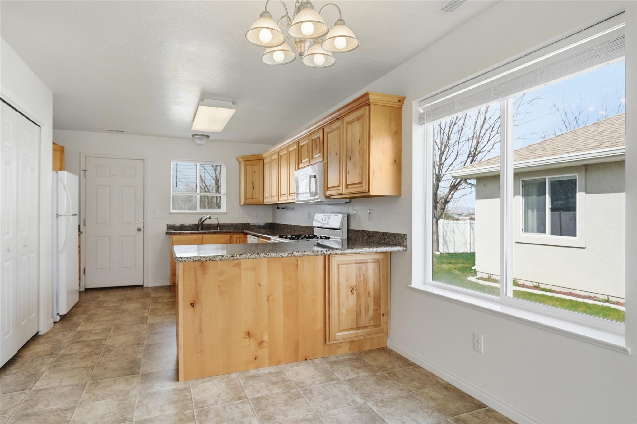 Kitchen featuring natural wood-finish cabinetry, stone-look countertops, and a built-in gas range