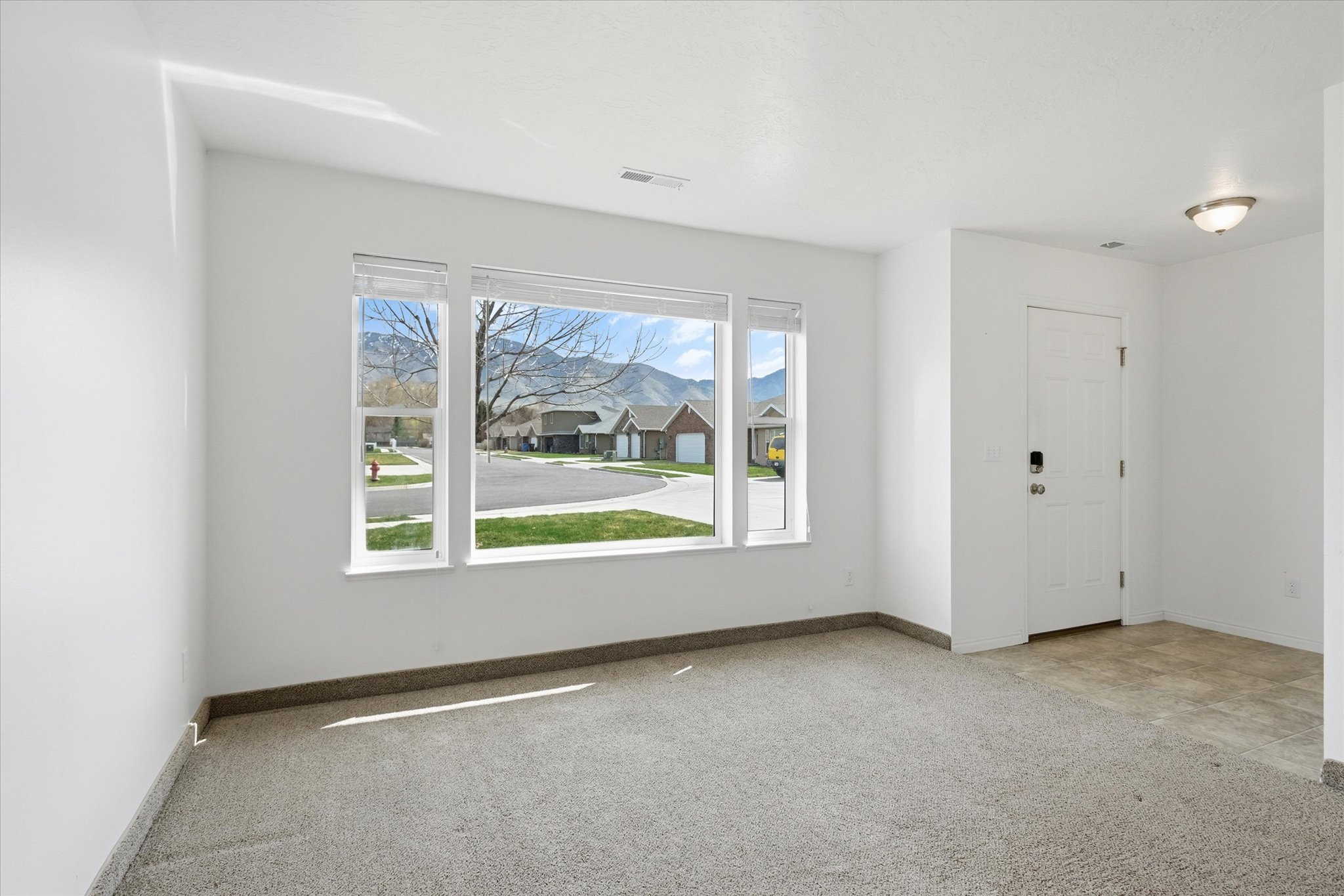 Bright living area featuring a large triple window with mountain scenery
