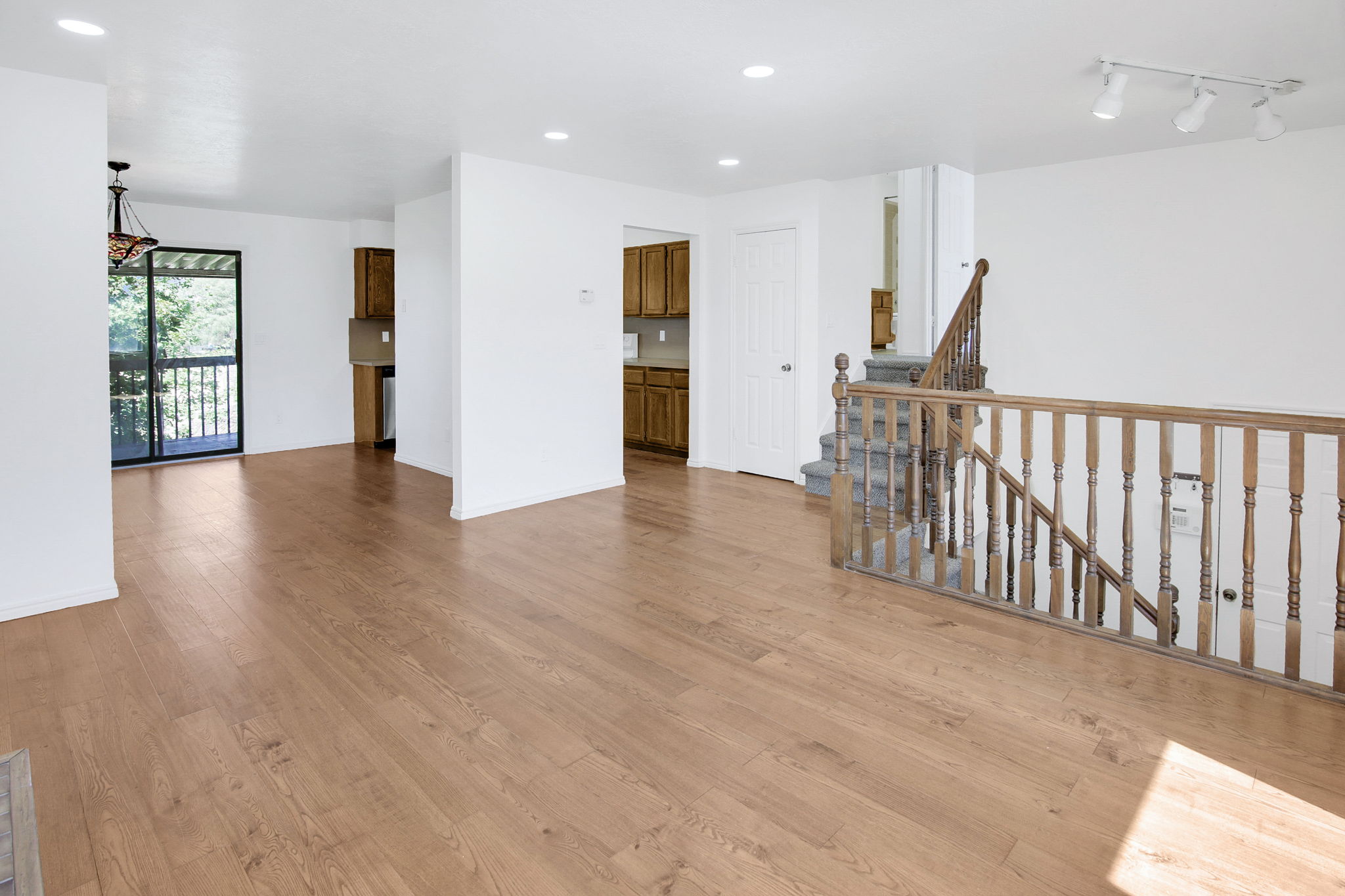Spacious interior featuring wood-finish flooring, white walls, and recessed lighting