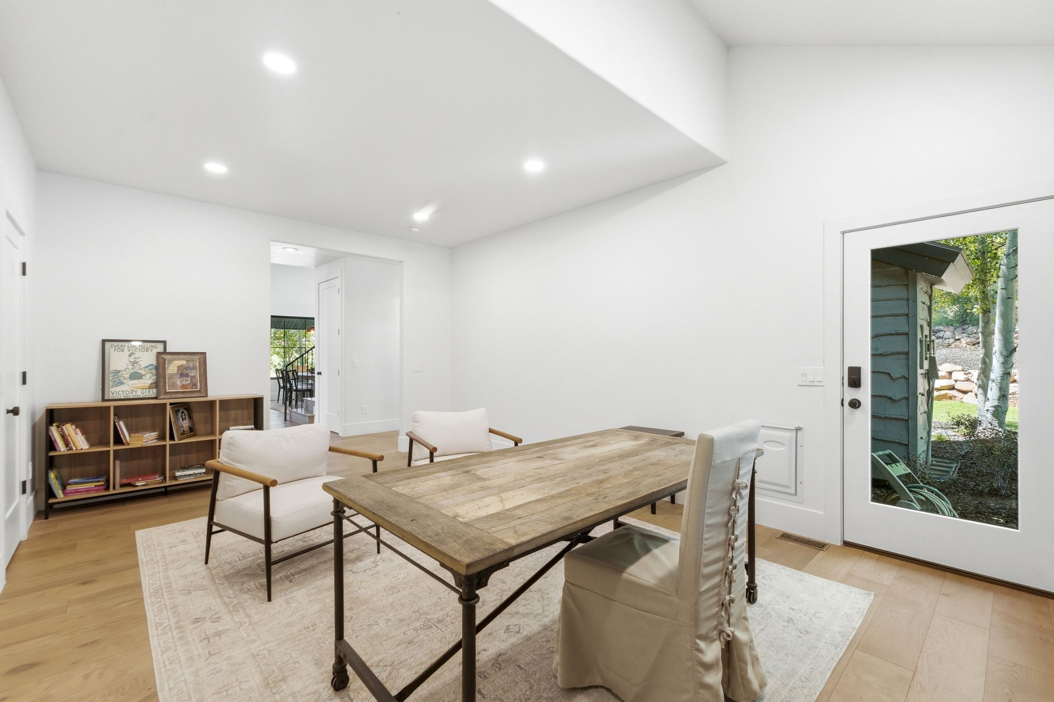 Bright interior space with wood-finish flooring, recessed lighting, and a vaulted ceiling