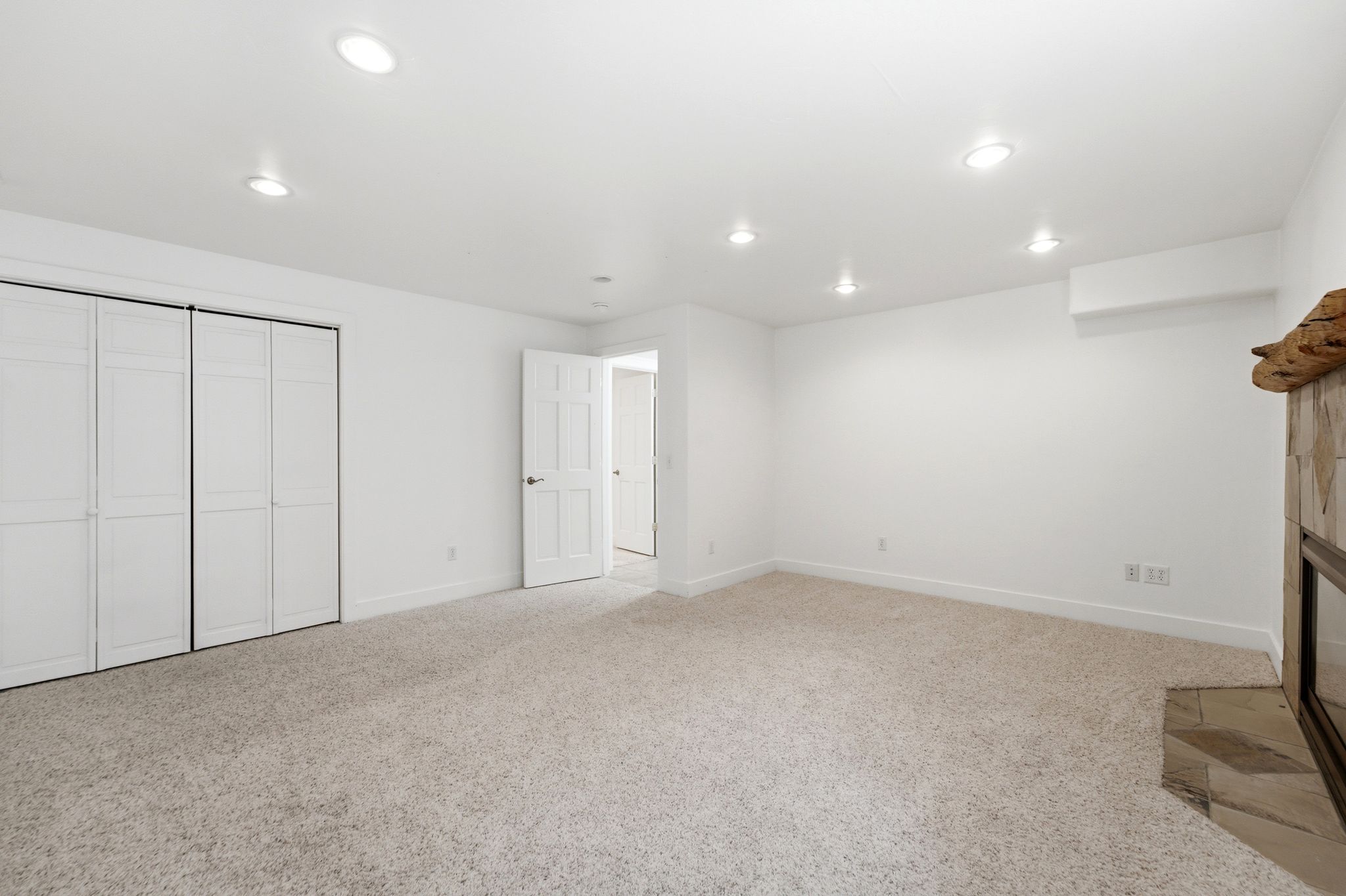 Spacious room featuring neutral carpeting and white walls