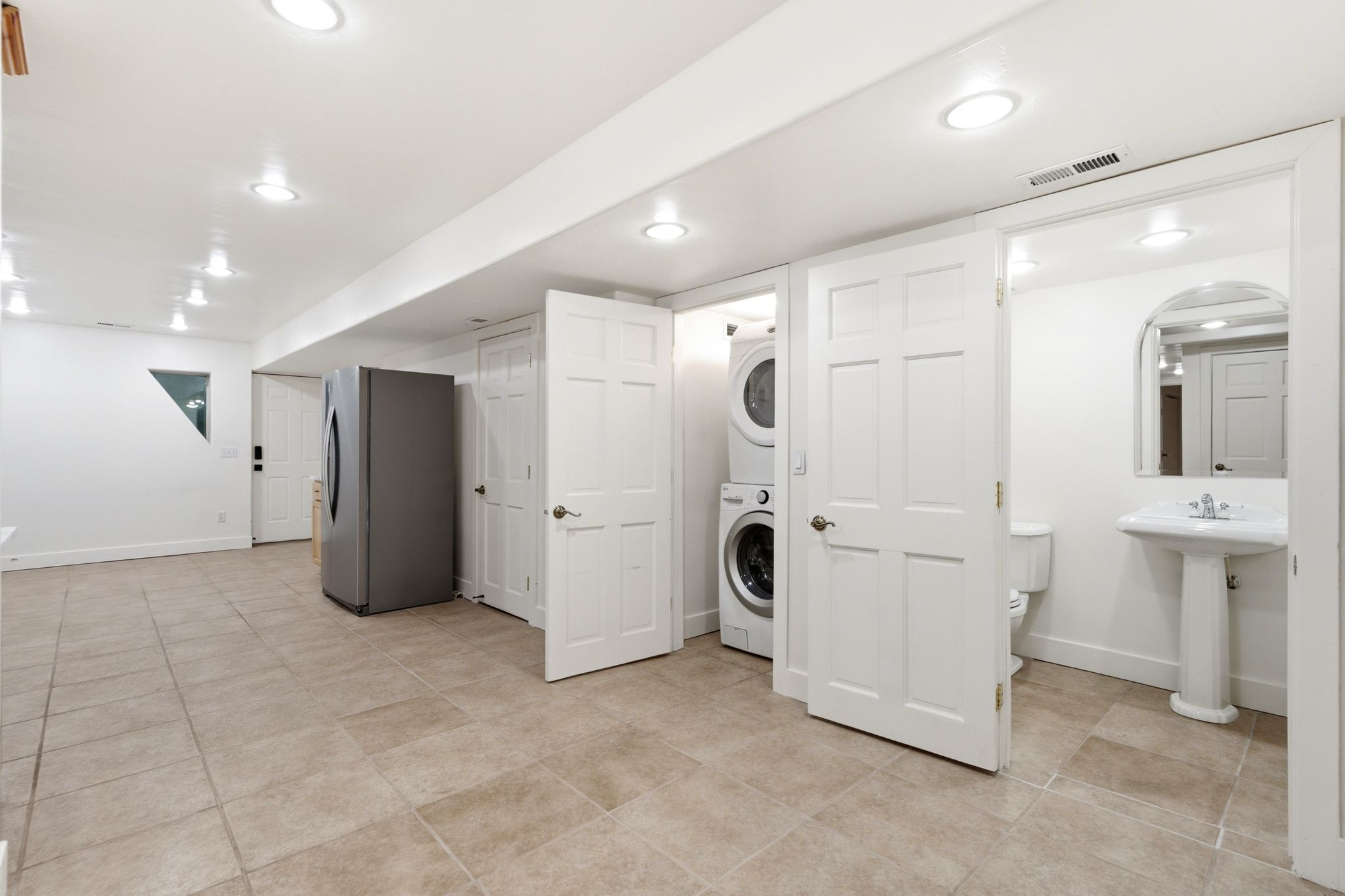 Spacious utility area featuring neutral tile flooring and recessed lighting
