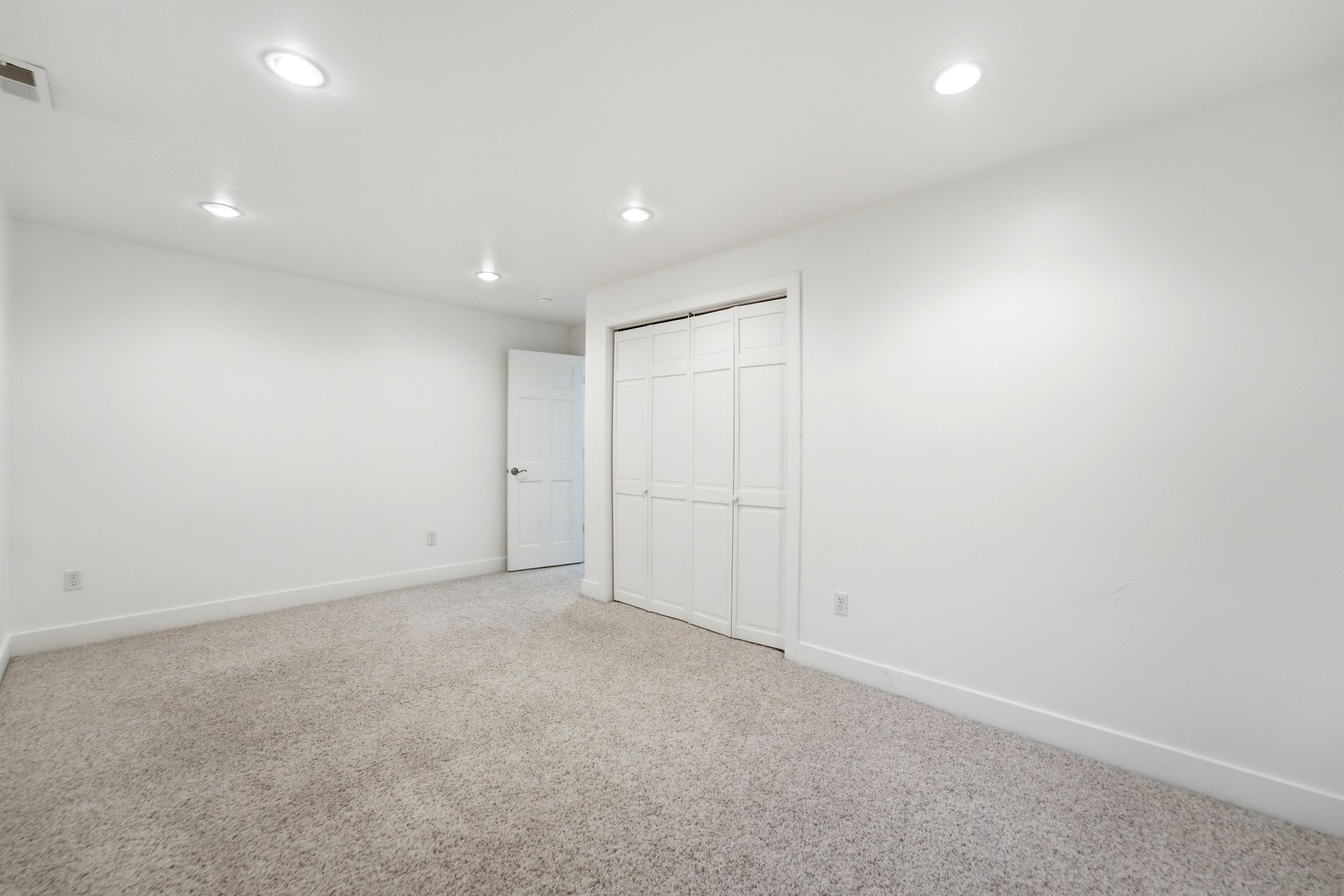 Room featuring light-colored carpeting, white walls, and recessed ceiling lighting