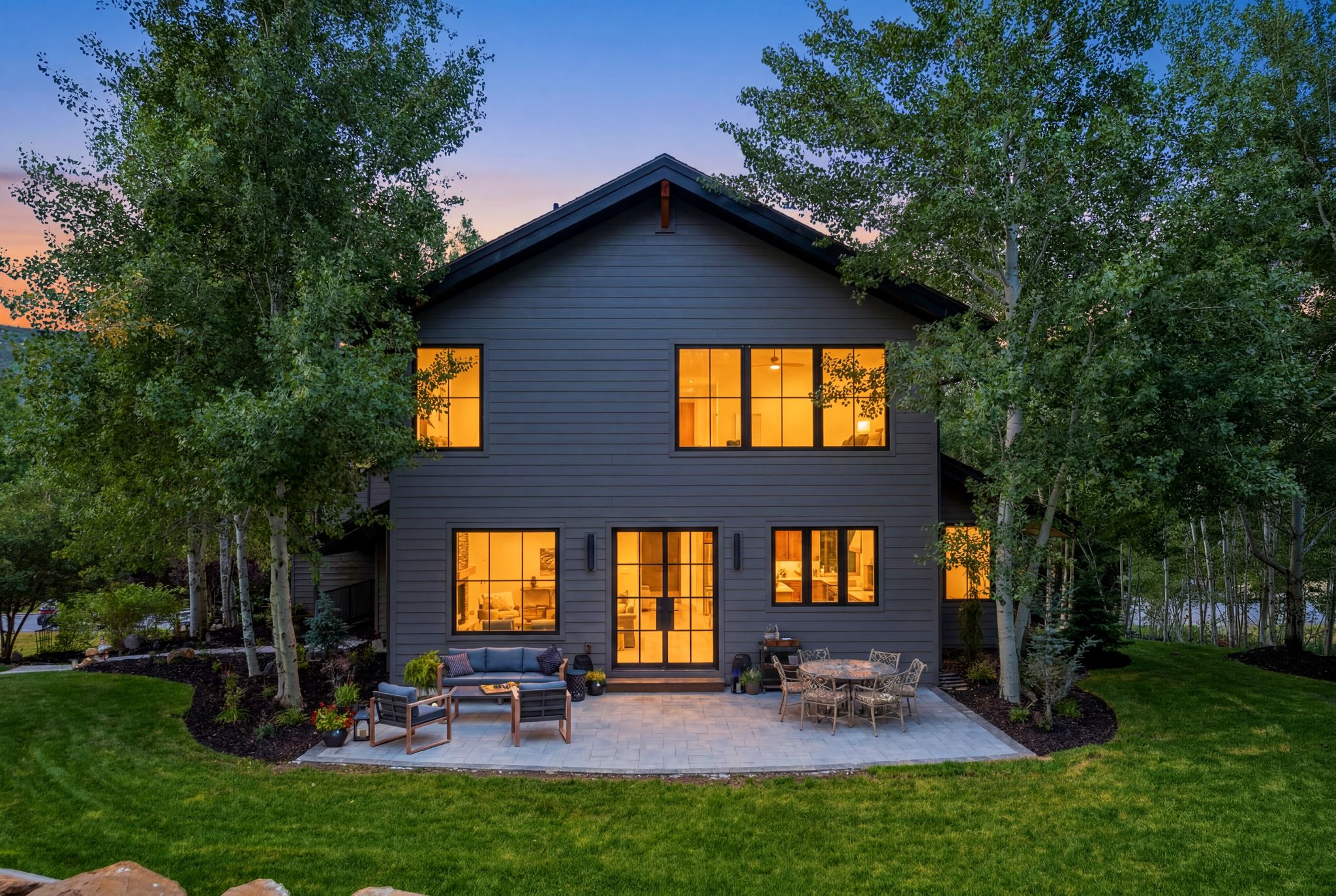 Contemporary dark-toned exterior featuring multiple large windows and a gabled roofline