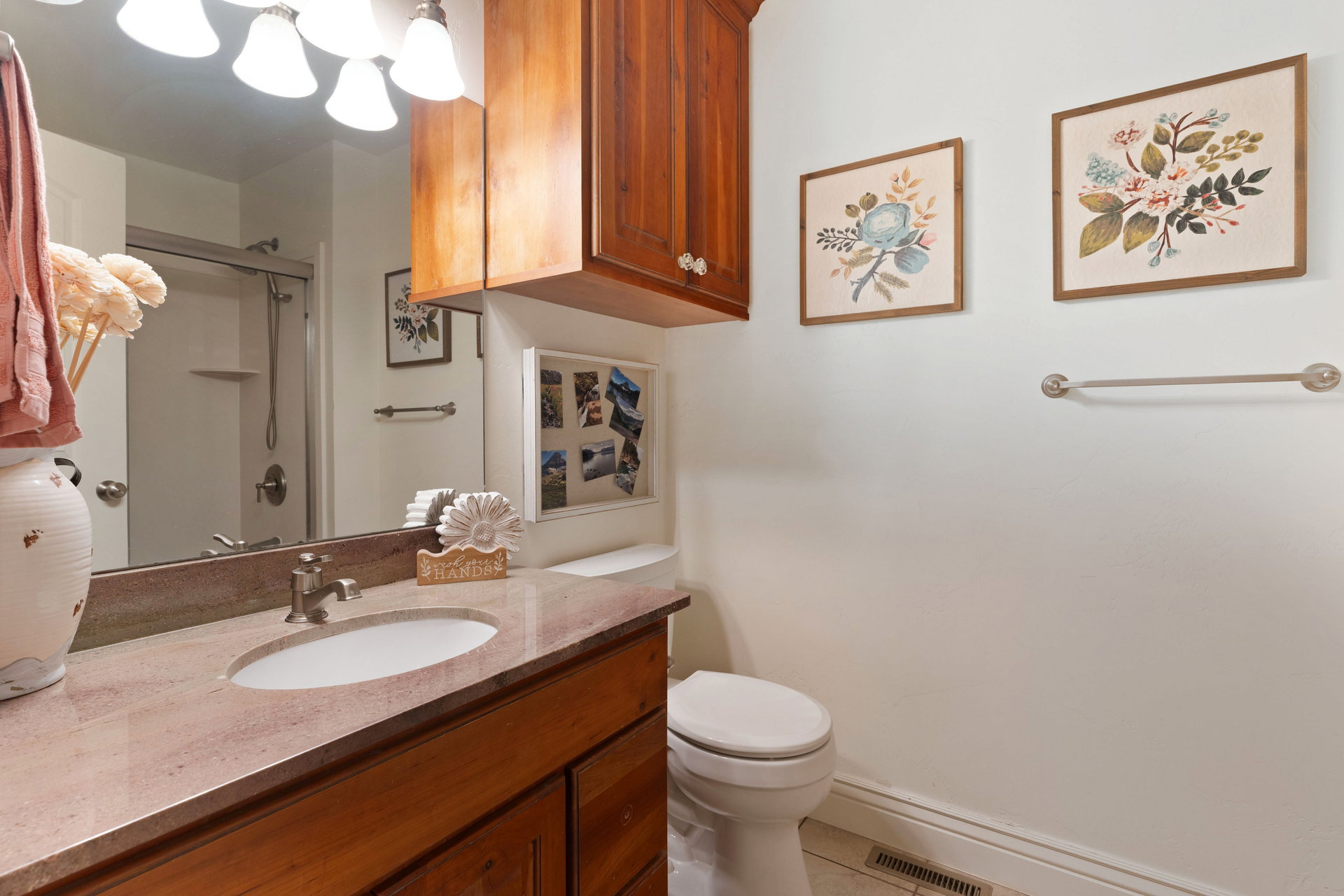 Bathroom featuring a single vanity with an integrated sink, a light-toned countertop, and wood-finish cabinetry