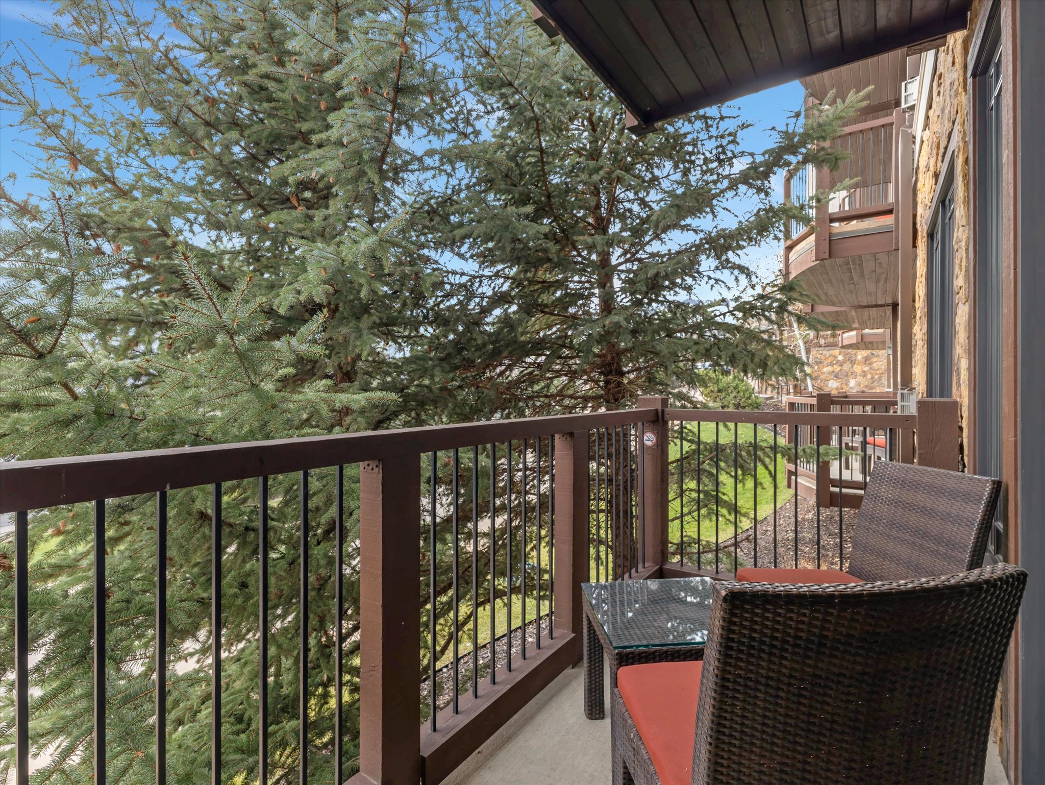 Private balcony with dark wood railing and slatted posts