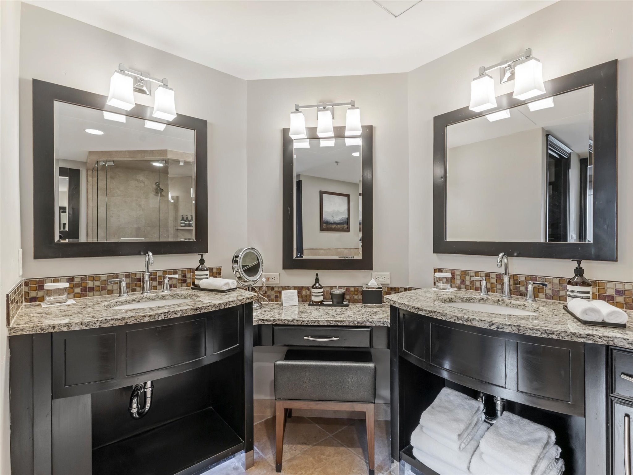 Dual vanity with granite countertops, undermount sinks, and dark wood cabinetry