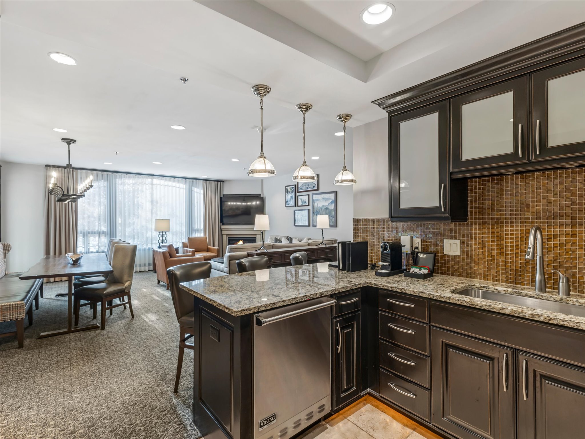Kitchen island featuring granite countertops, stainless steel dishwasher, and a mosaic tile backsplash