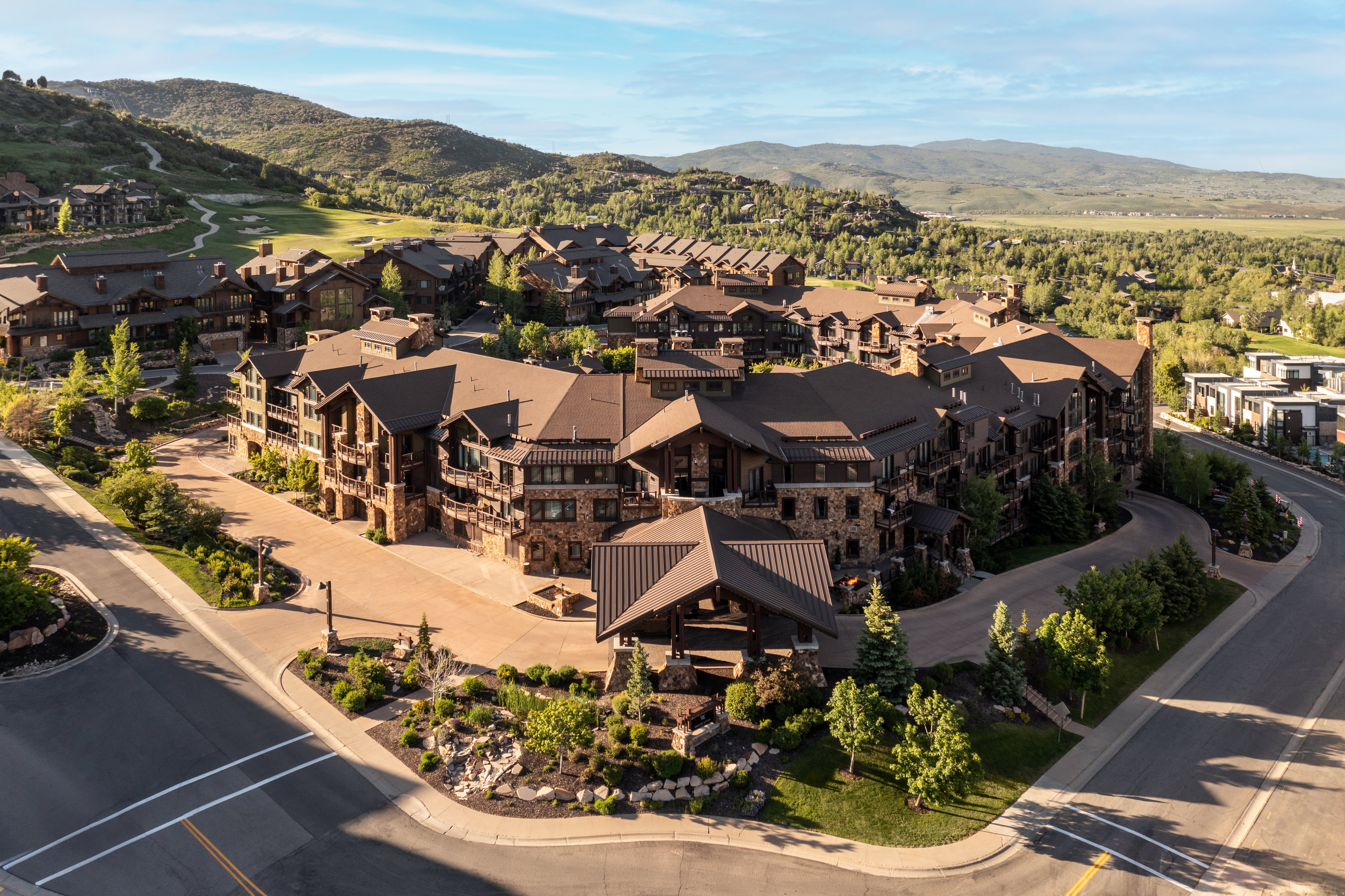 Expansive mountain-style community featuring multi-story buildings with stone and wood siding, pitched roofs, and multiple balconies