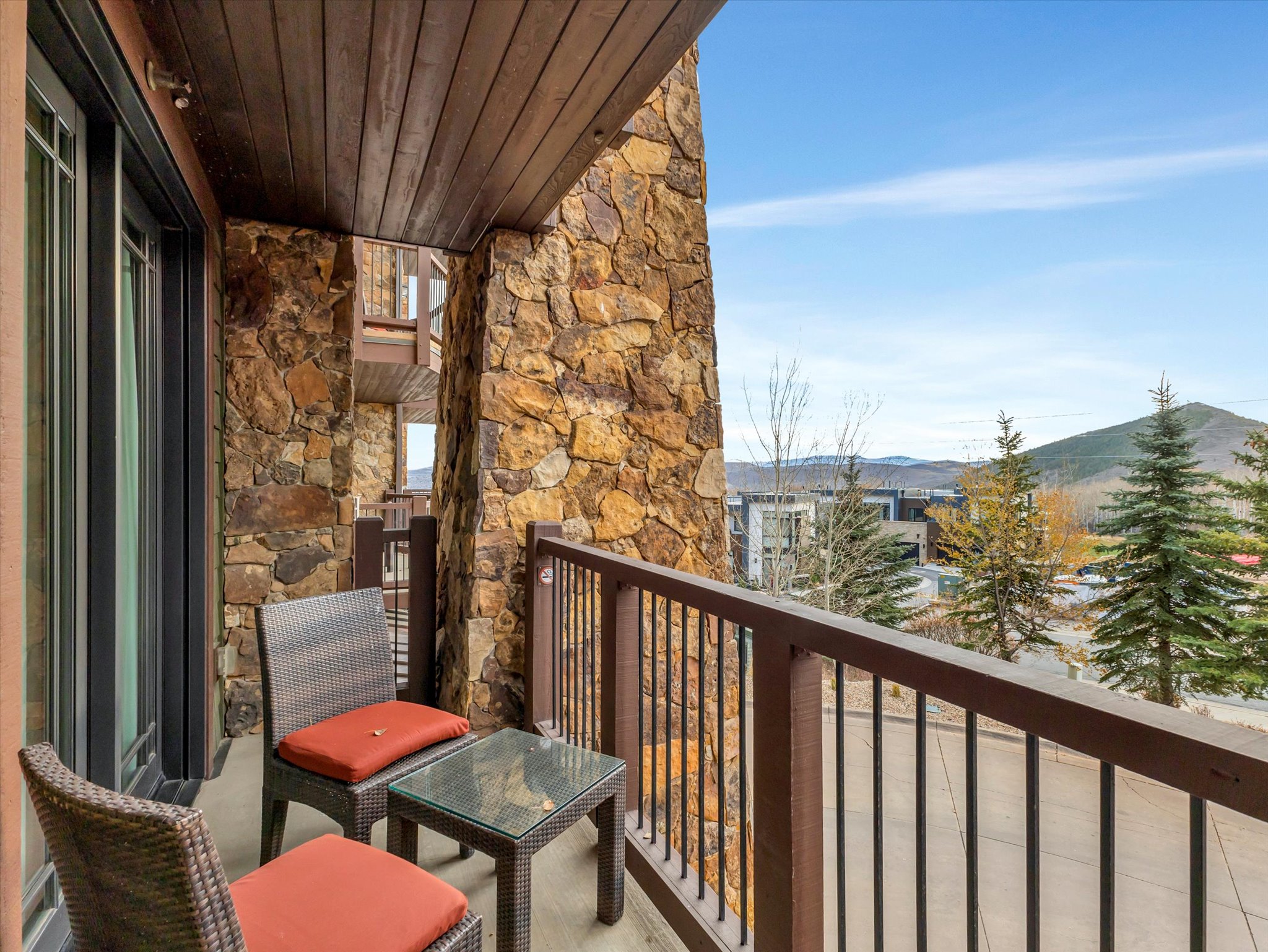 Balcony with stone wall accents and a wood-slat ceiling