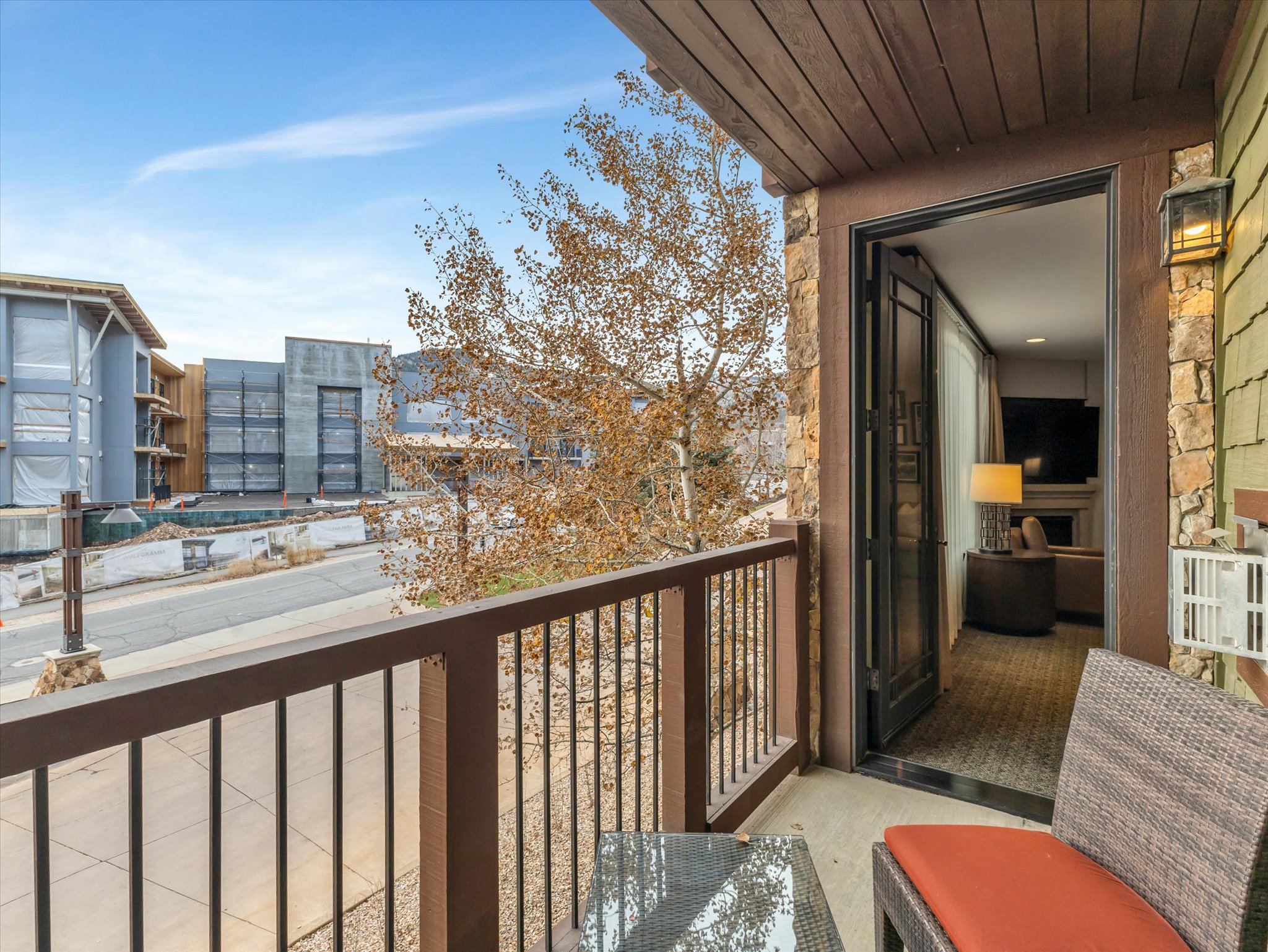 Private balcony featuring stone cladding accents and an open doorway to the interior