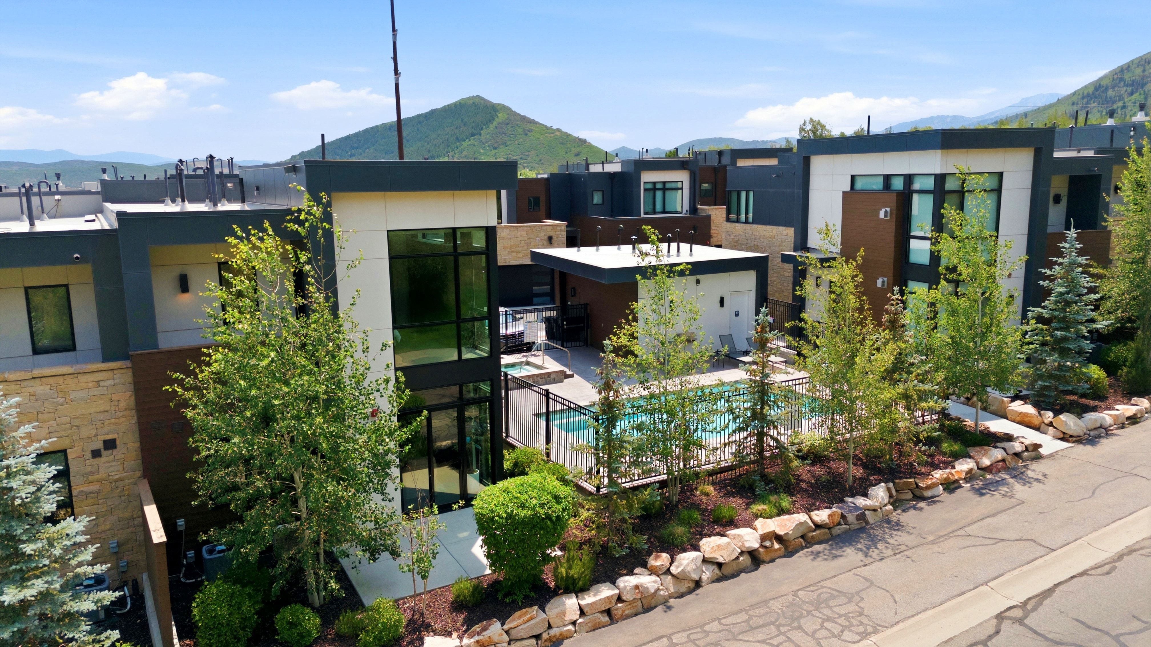 Modern multi-level exterior featuring large windows, a private pool area, and a built-in outdoor spa