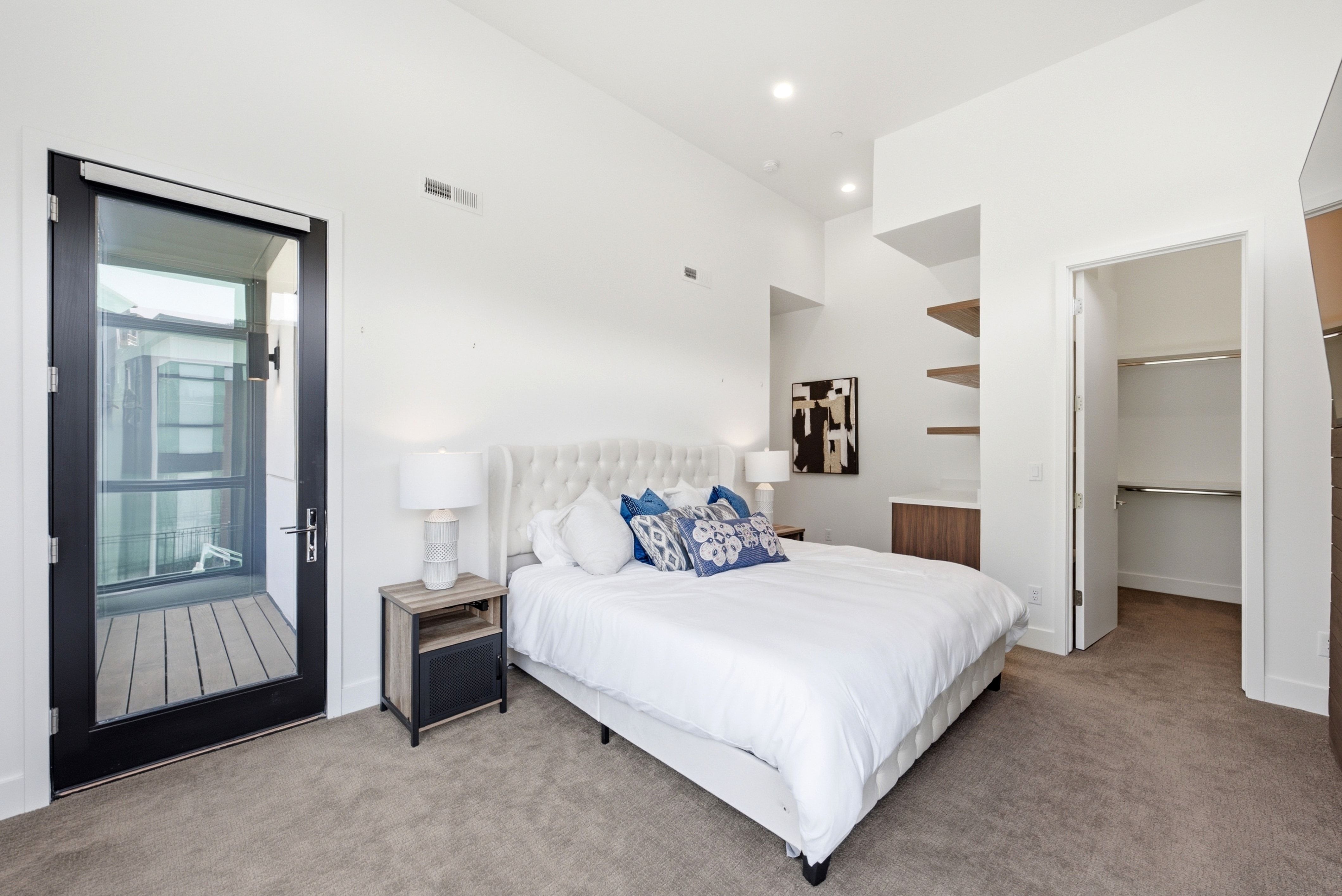 Bedroom featuring a full-light exterior door to a balcony, recessed lighting, vaulted ceilings, and built-in shelving
