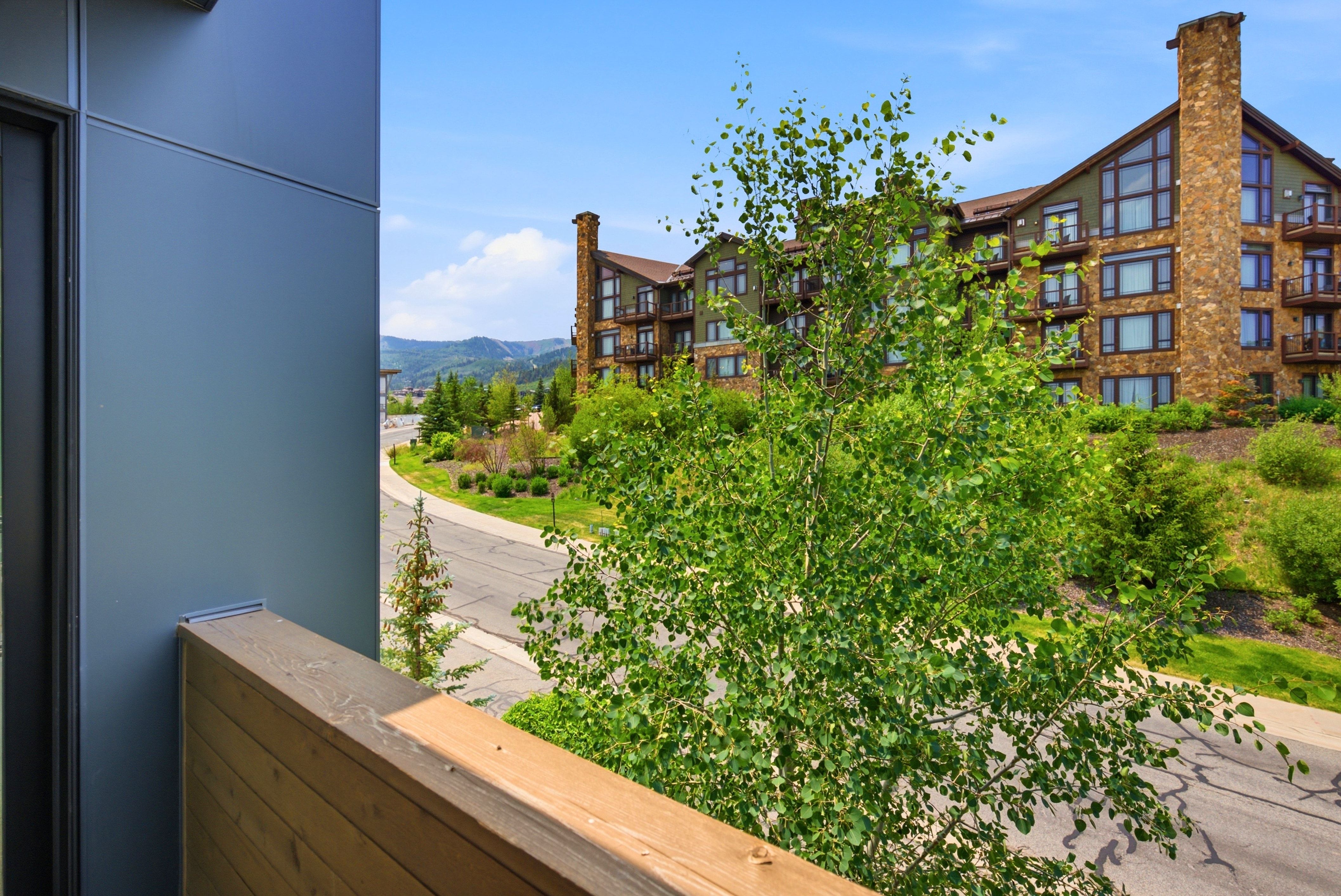 Balcony featuring a wood-finish railing and a modern metal panel exterior