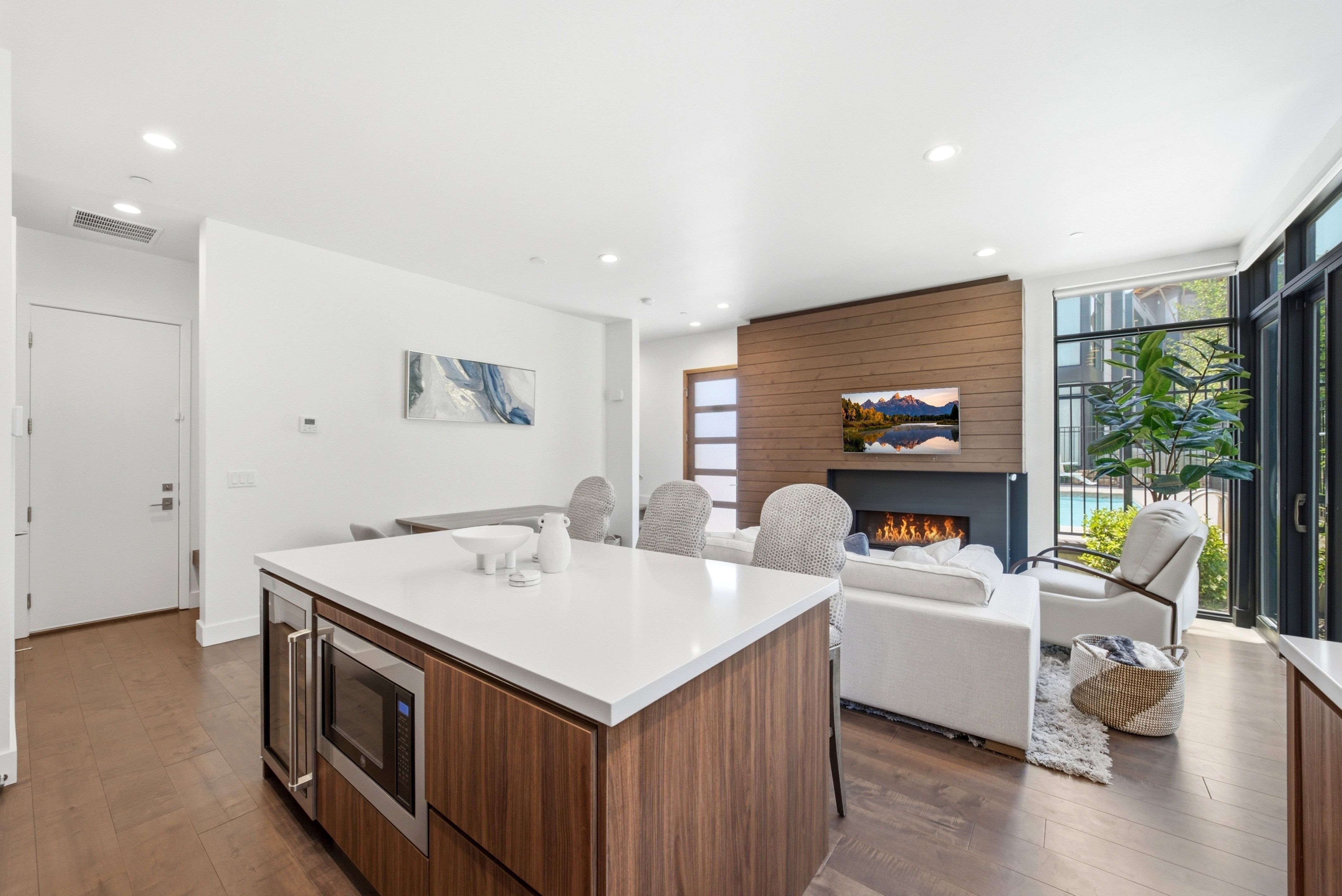 Kitchen island featuring a white countertop, built-in microwave, and integrated beverage cooler