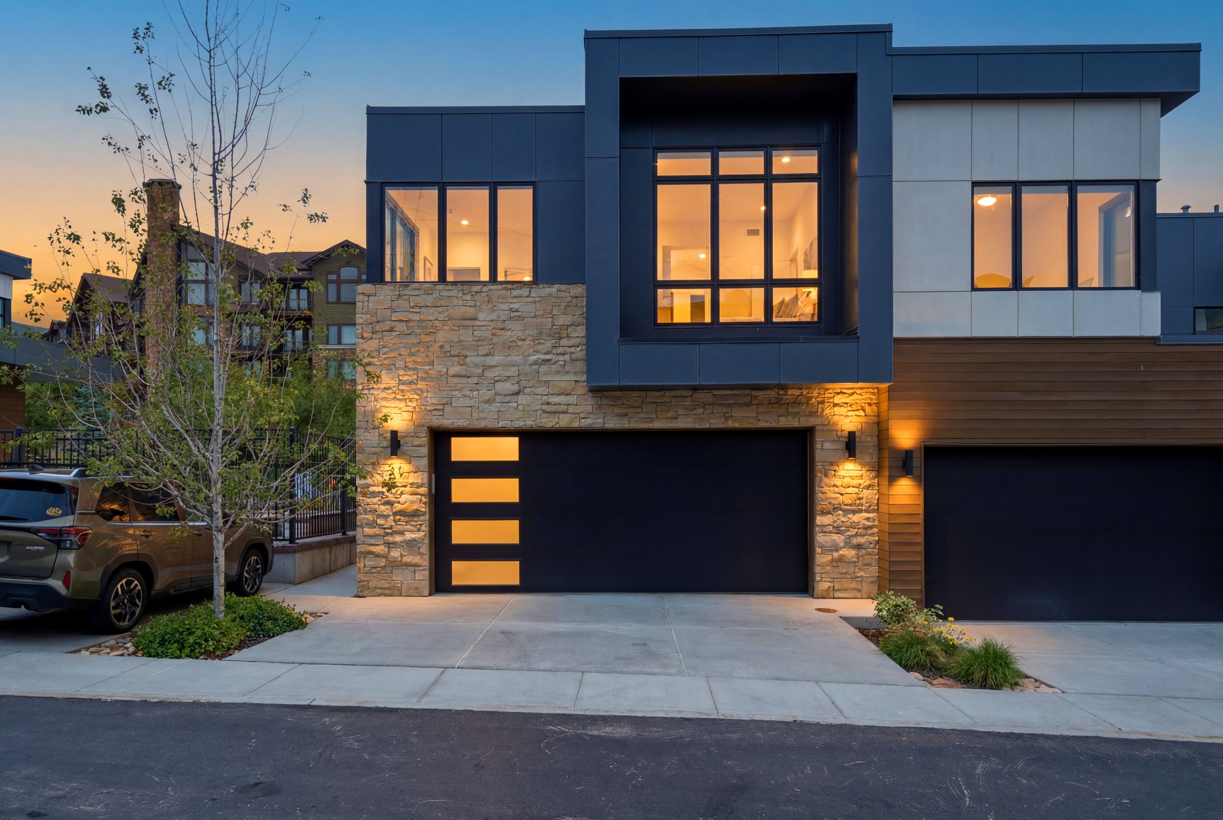 Modern multi-level facade featuring stone veneer accents and dark siding