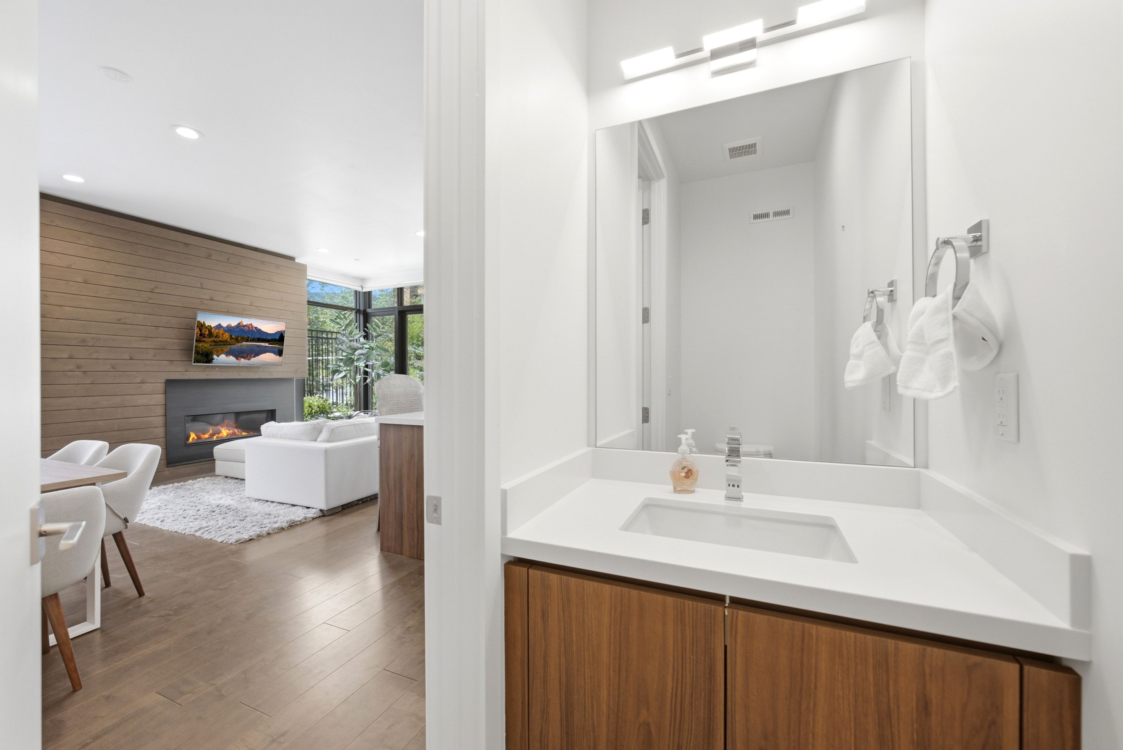 Modern vanity with a rectangular sink, white countertop, and wood-finish cabinetry