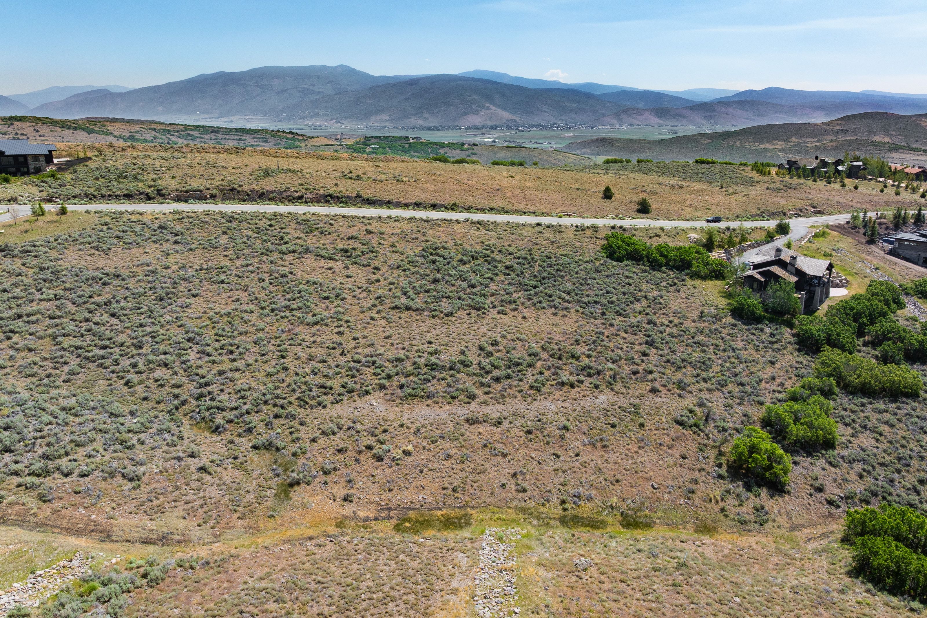 Expansive undeveloped lot featuring natural vegetation and distant mountain ranges