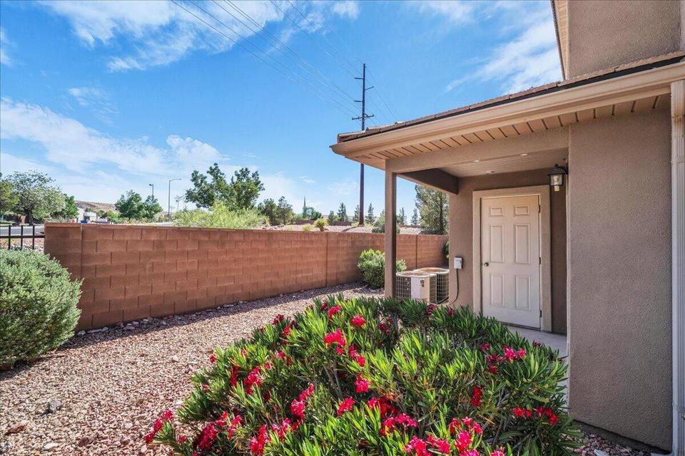 Covered entryway with a paneled door, exterior wall lantern, and stucco finish