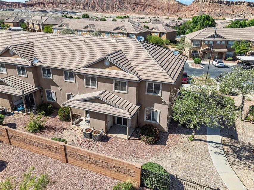 Multi-story townhome with stucco exterior and tiled roofing