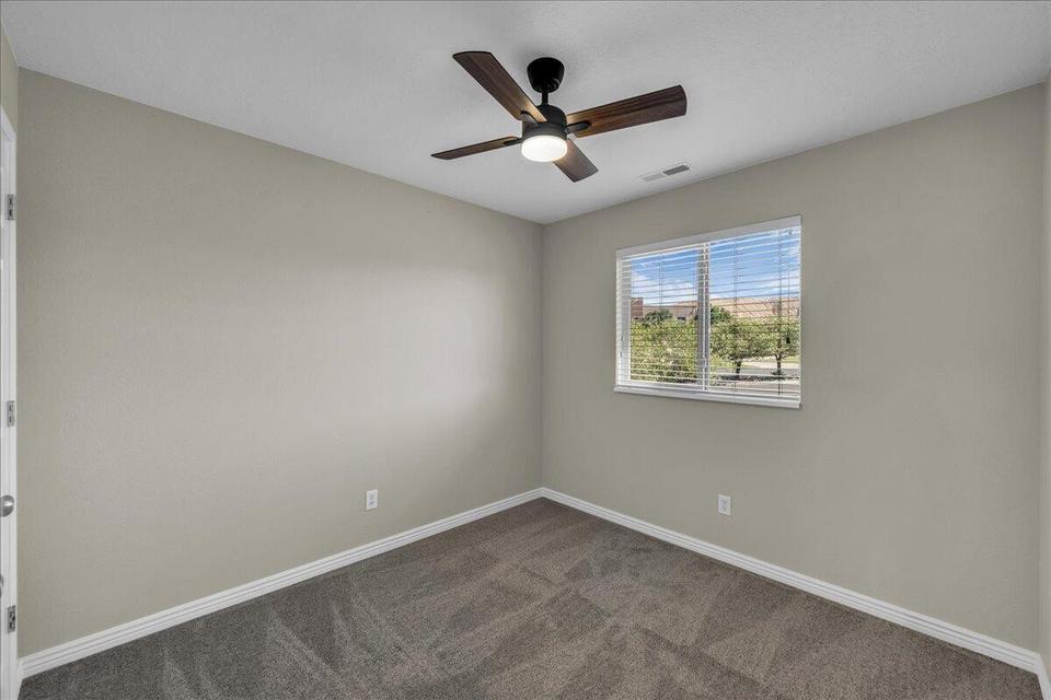Room featuring a ceiling fan with integrated lighting, a window with horizontal blinds, neutral wall paint, white baseboards, and carpet flooring