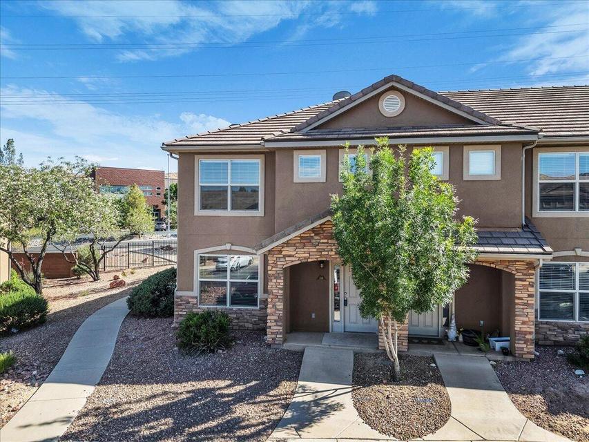Two-story stucco exterior with stone accents and a complementary tile roof