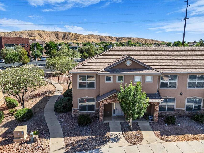 Stucco exterior featuring a tiled roof and stone accents