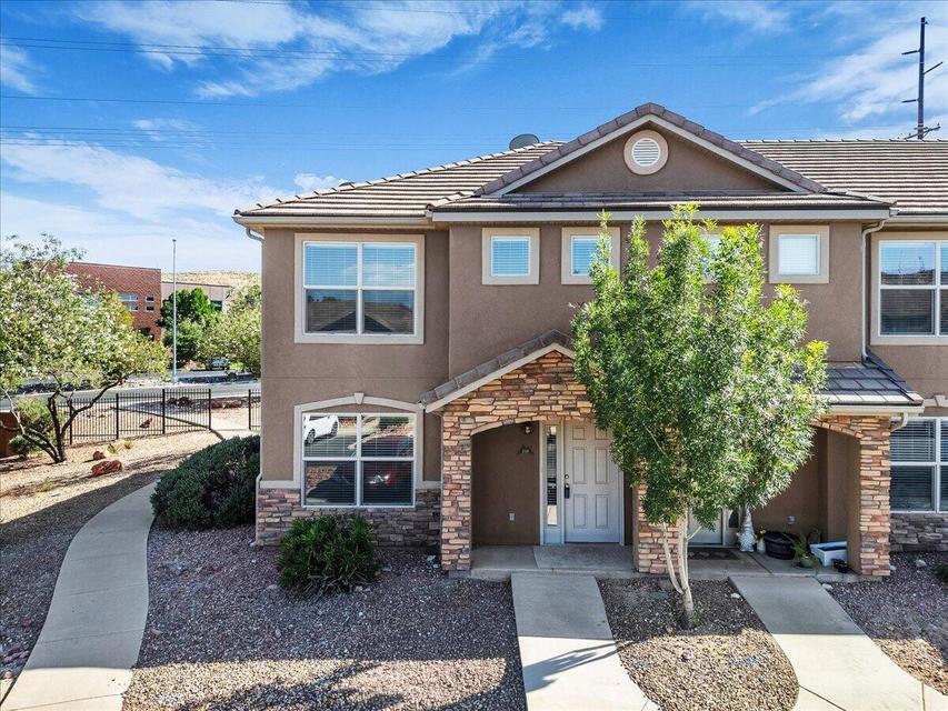 Contemporary stucco exterior with stone accents and a covered entry