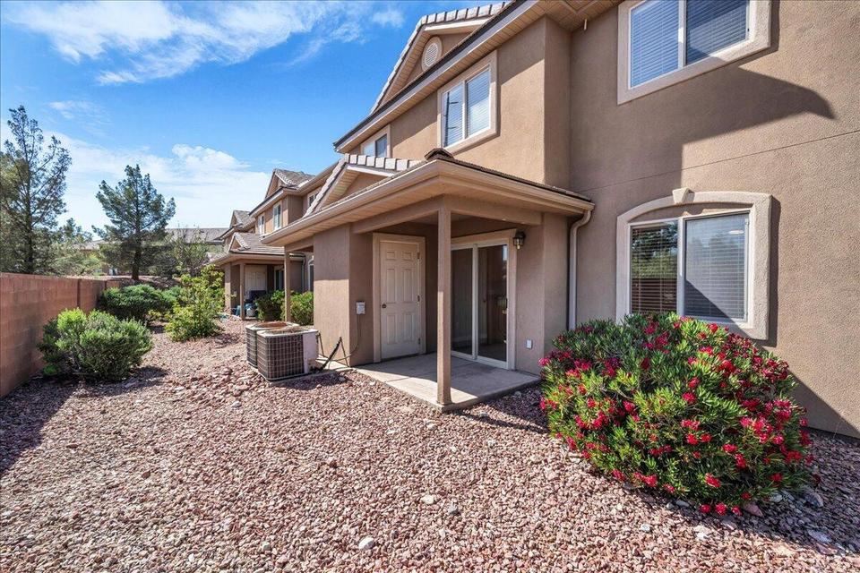 Stucco exterior with decorative window trim and a covered patio featuring sliding glass doors