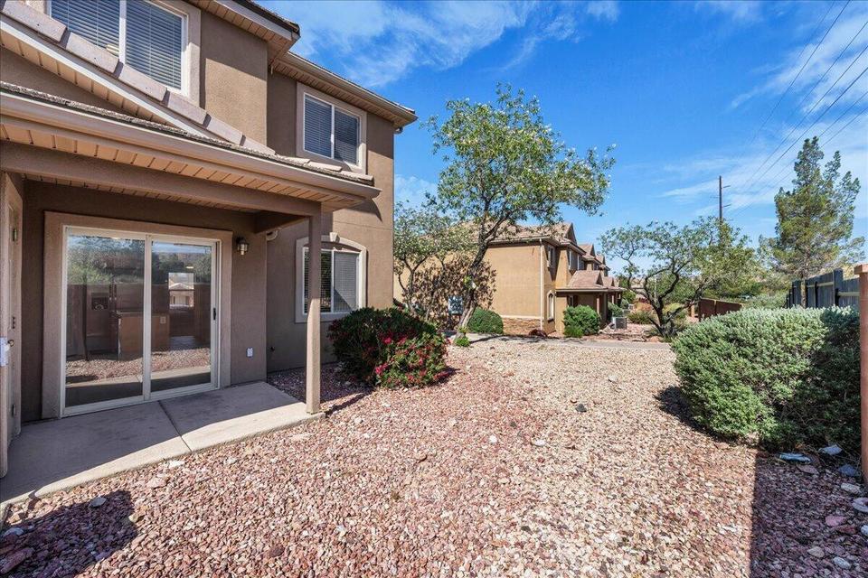 Rear exterior featuring a covered patio with concrete flooring and sliding glass door