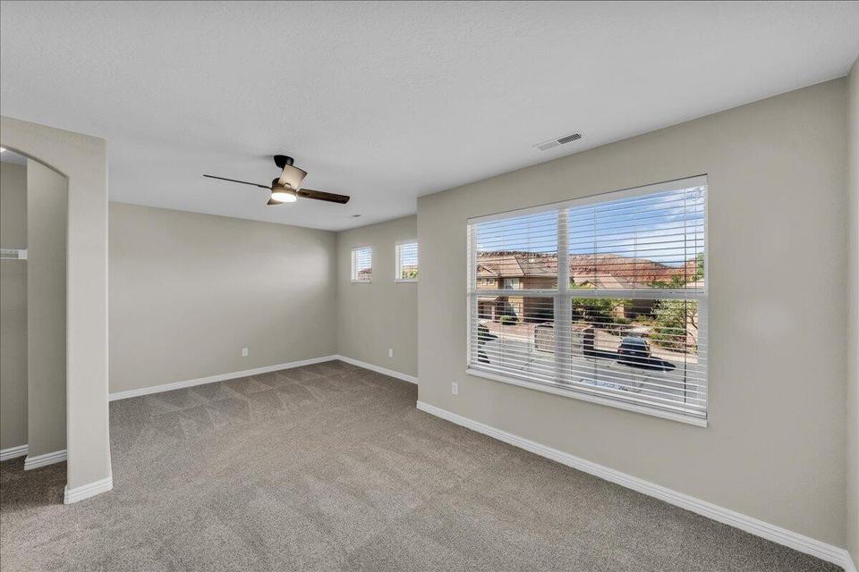 Spacious room featuring neutral carpeting and light gray walls