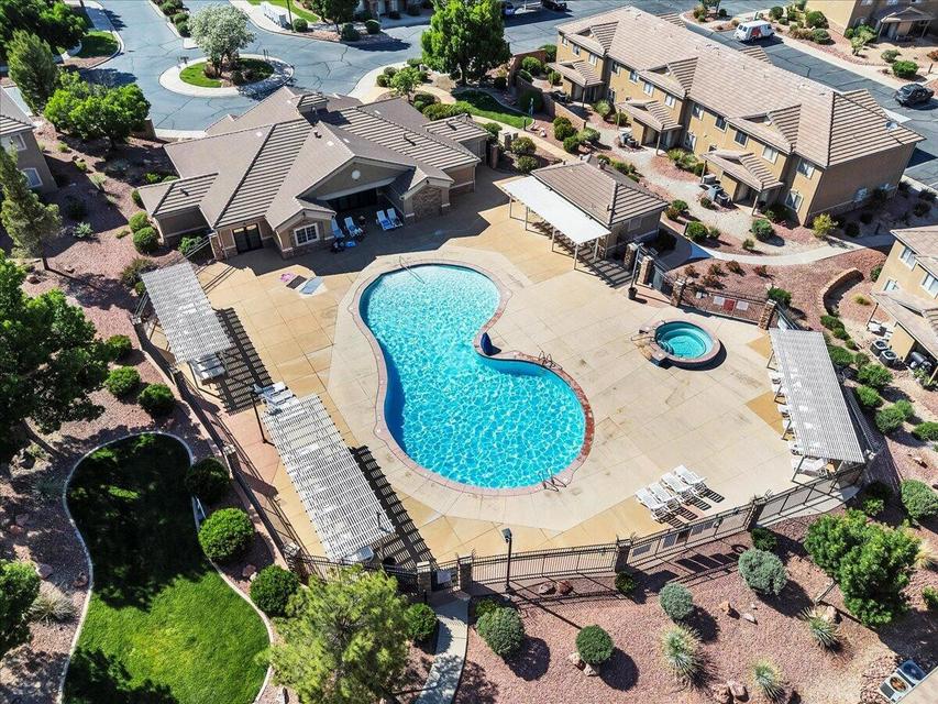 Resort-style pool area featuring a freeform swimming pool, integrated spa, and expansive concrete decking
