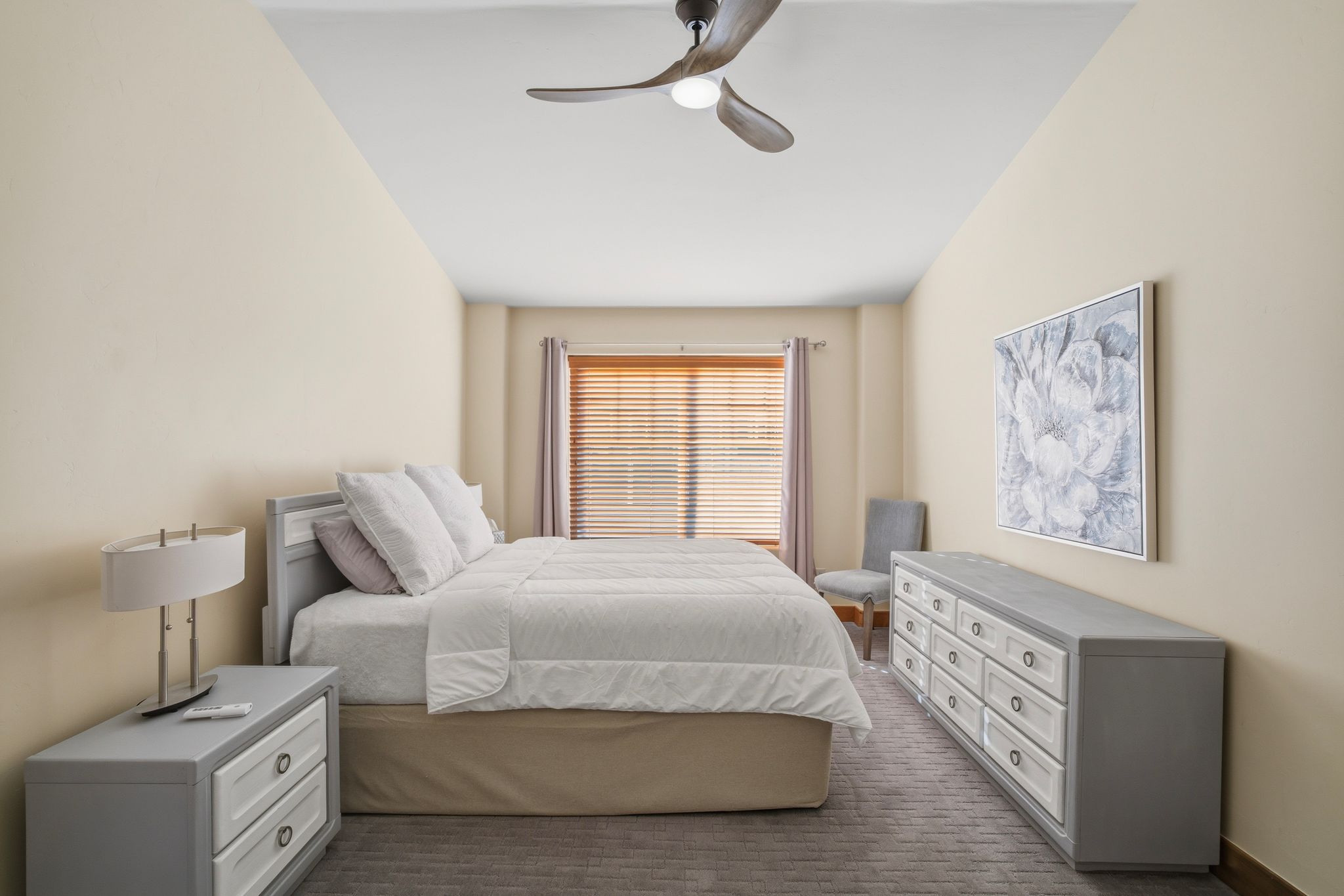 Recessed window with wood-finish blinds and neutral drapes