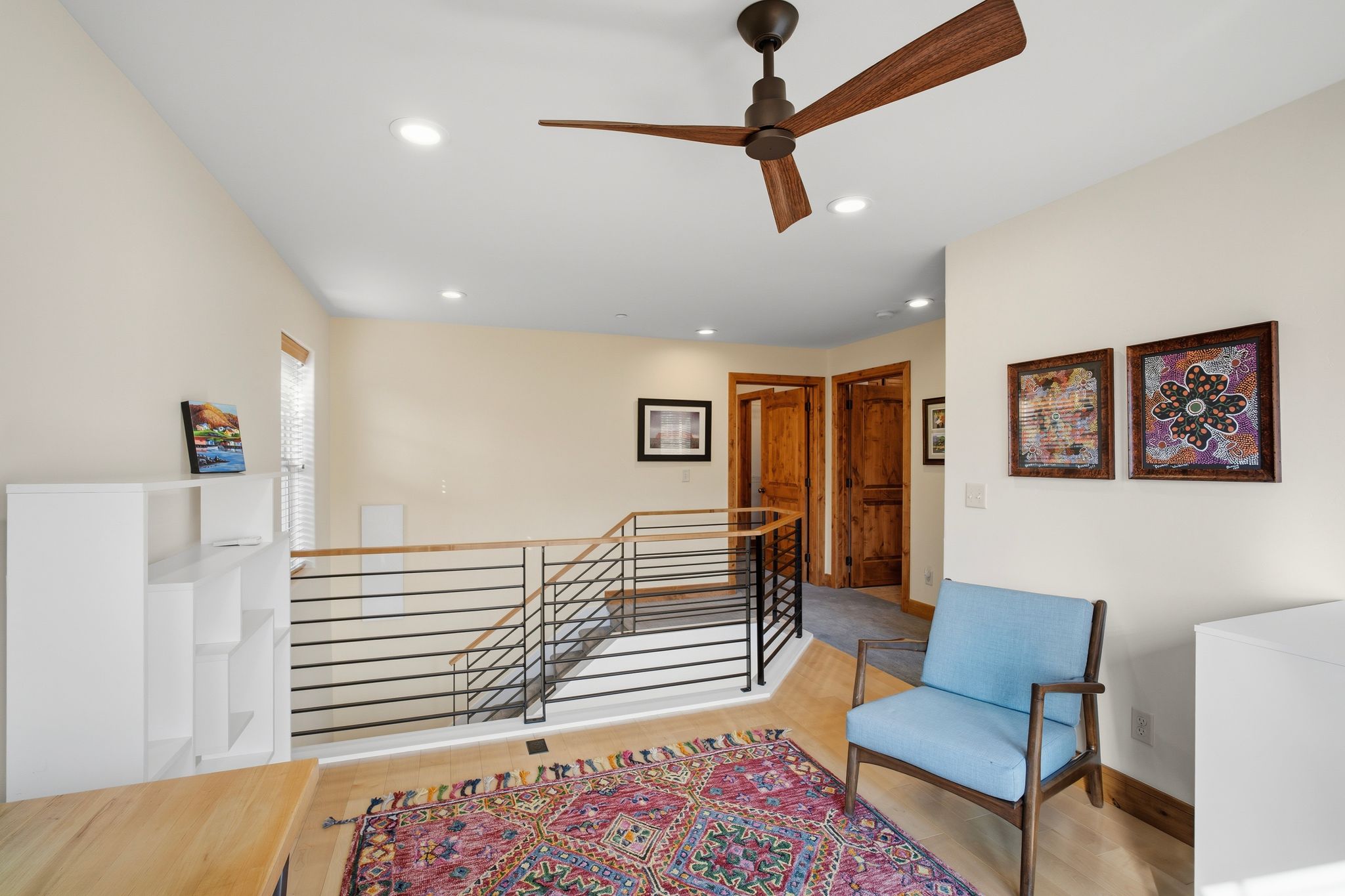 Upper-level landing featuring a wood-finish flooring, recessed lighting, and a modern ceiling fan