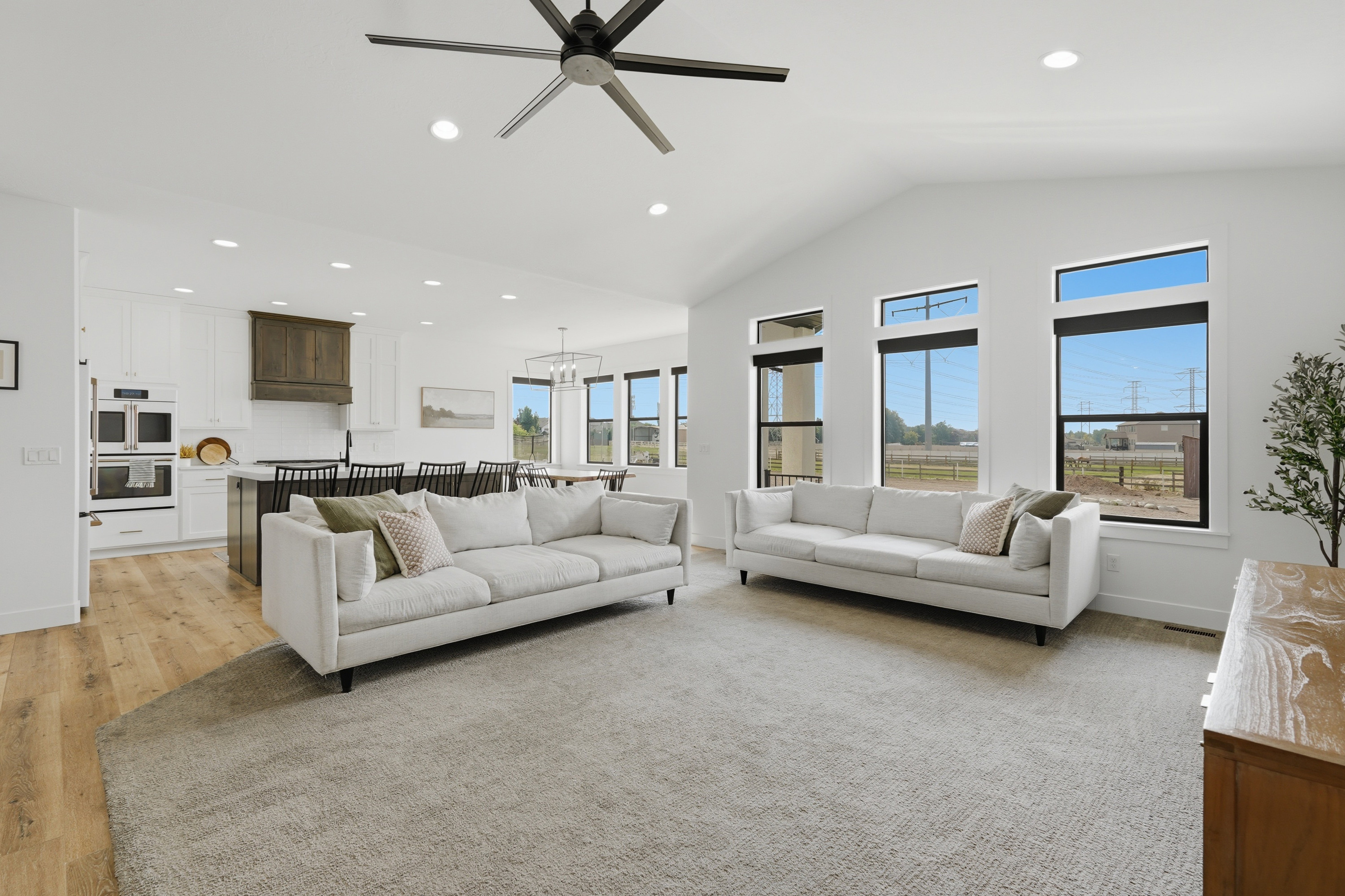 Expansive open-concept living area featuring a vaulted ceiling and contemporary ceiling fan