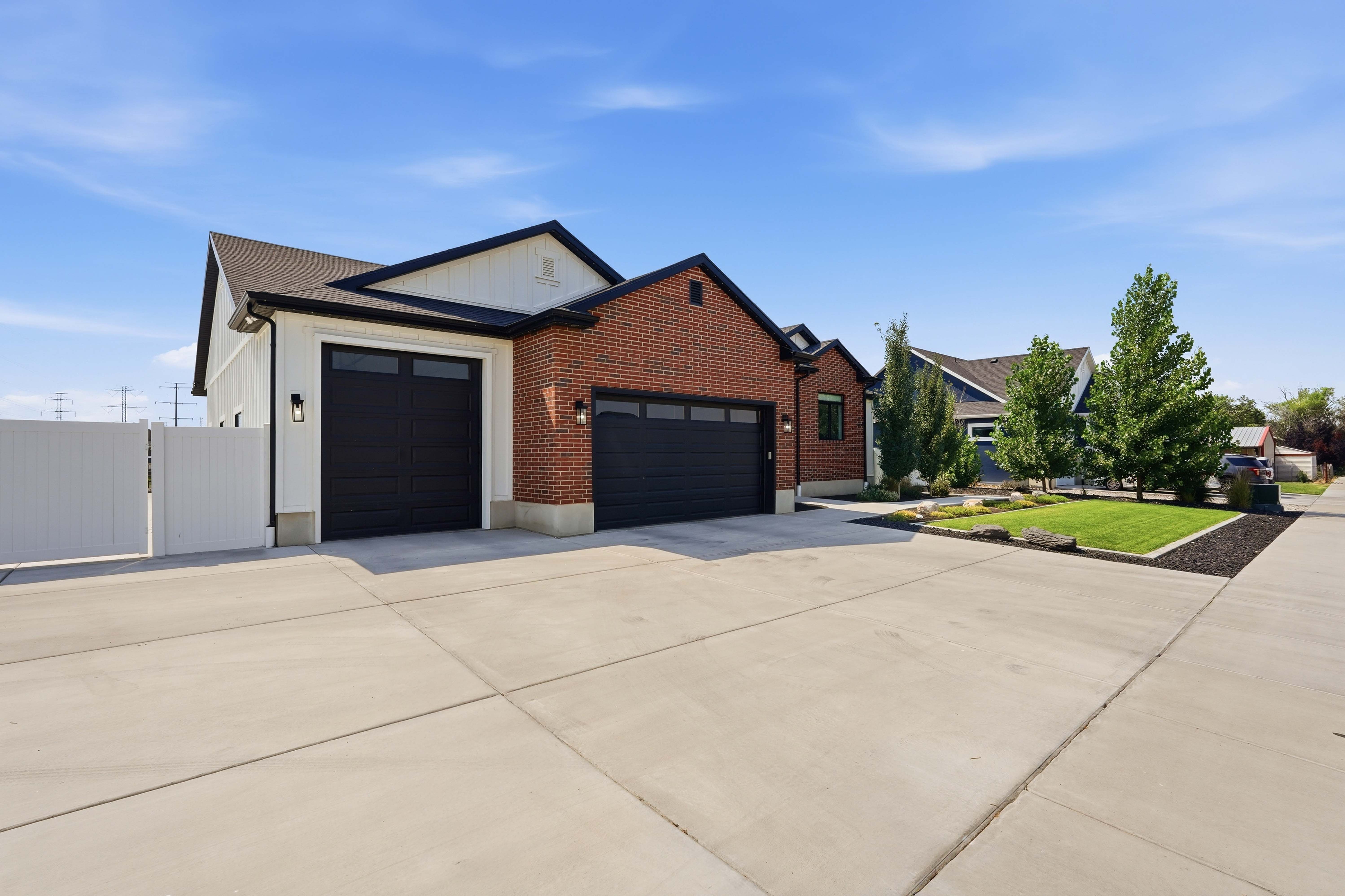 Modern farmhouse-style exterior featuring brick and vertical white siding