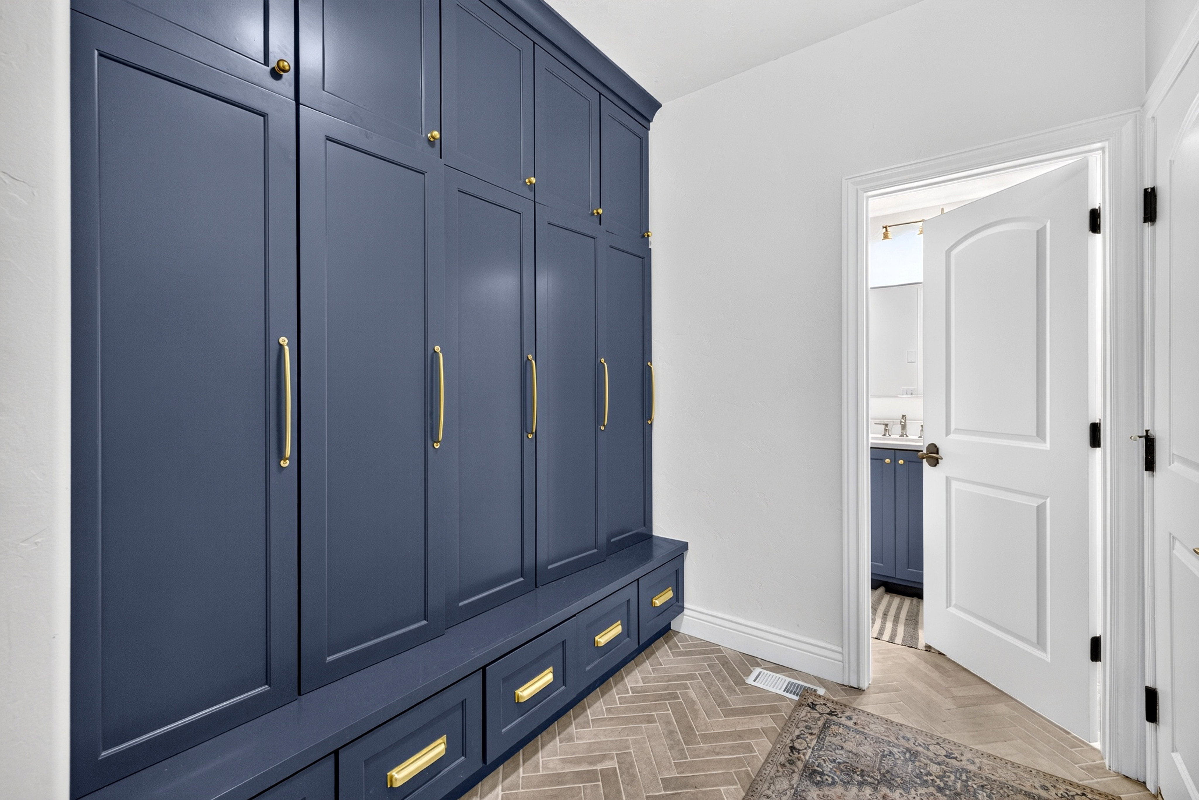 Built-in navy cabinetry with gold-tone hardware, providing extensive storage