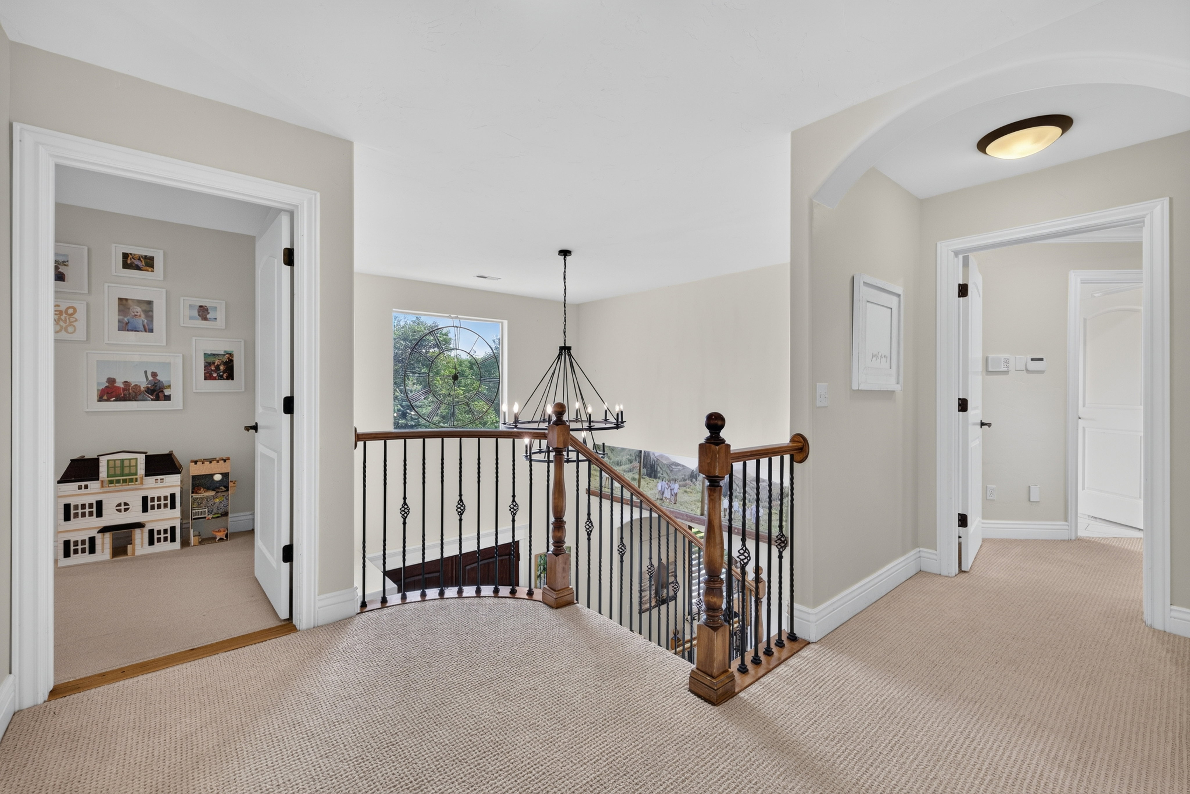 Upper-level hallway with neutral carpeting, white trim, and light-toned walls