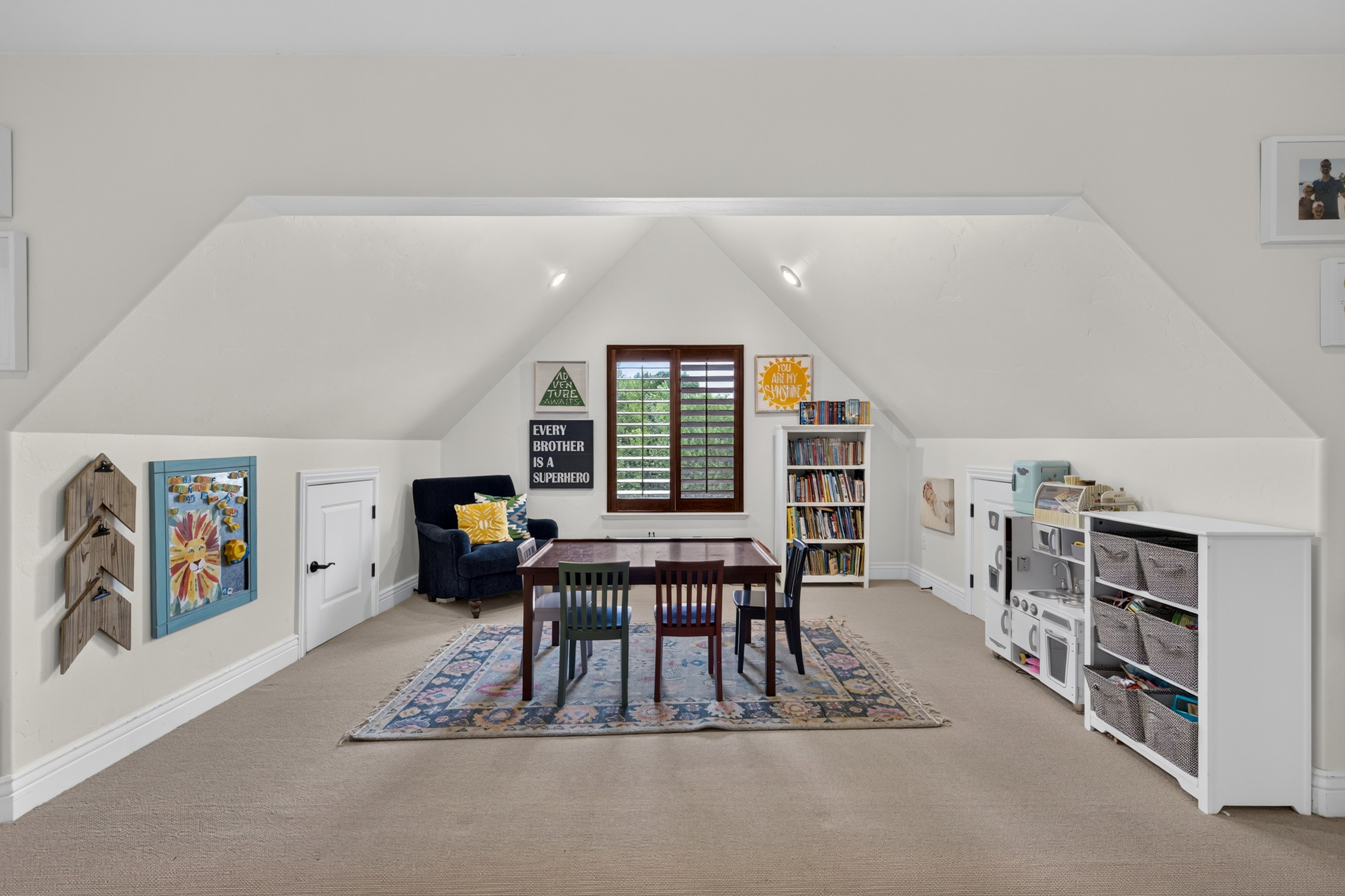 Expansive attic space featuring sloped ceilings and recessed lighting