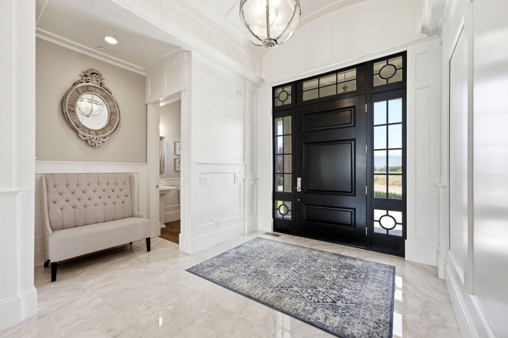 Grand entry featuring a substantial dark-toned main door with sidelights and transom windows