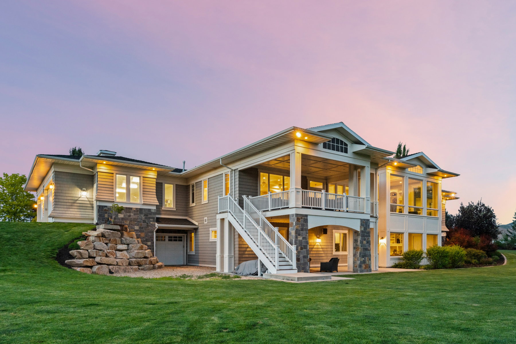 Exterior featuring light gray siding, stone accents, and a multi-level design