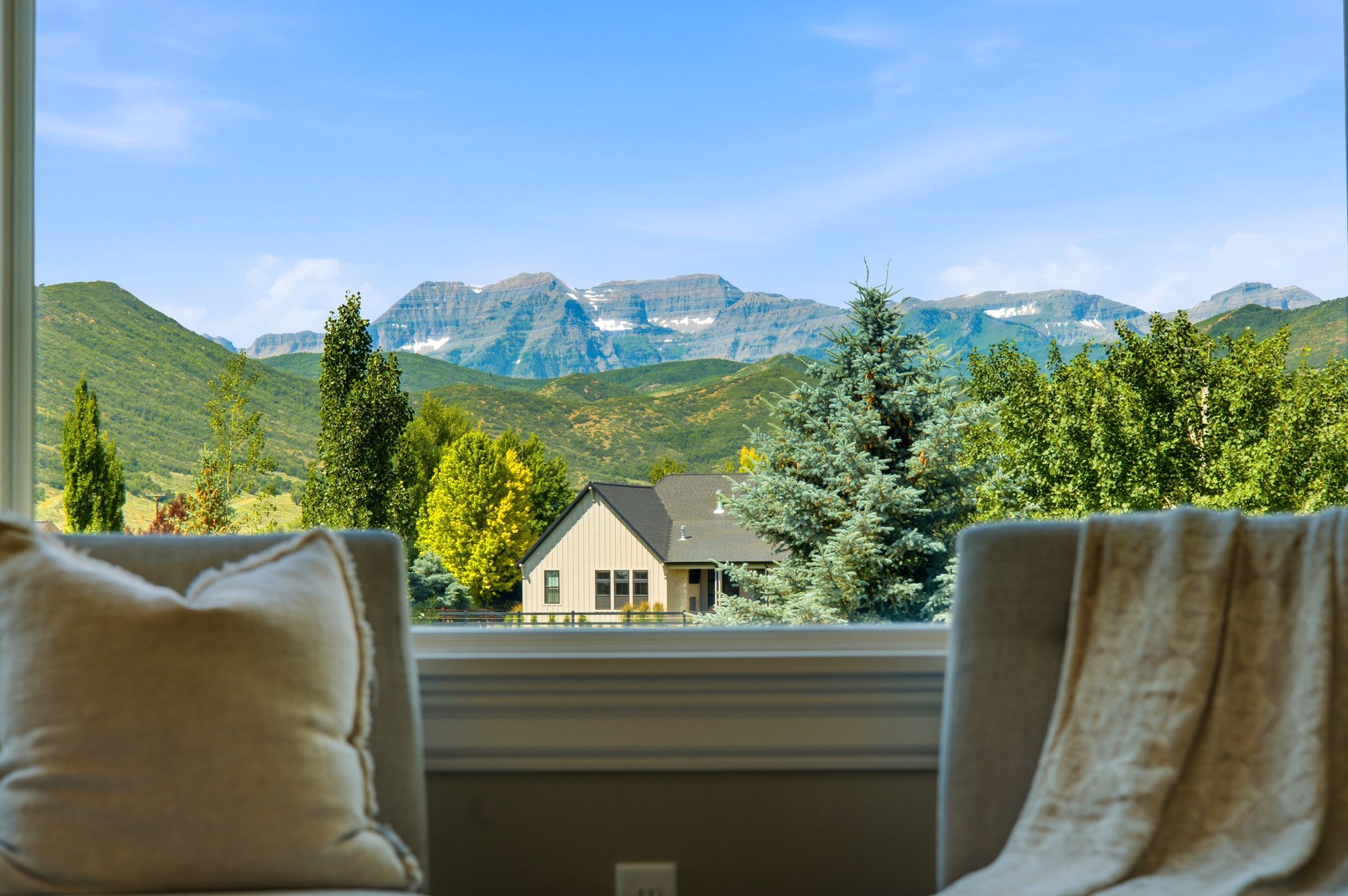 Expansive window framing a mountain range with snow-capped peaks