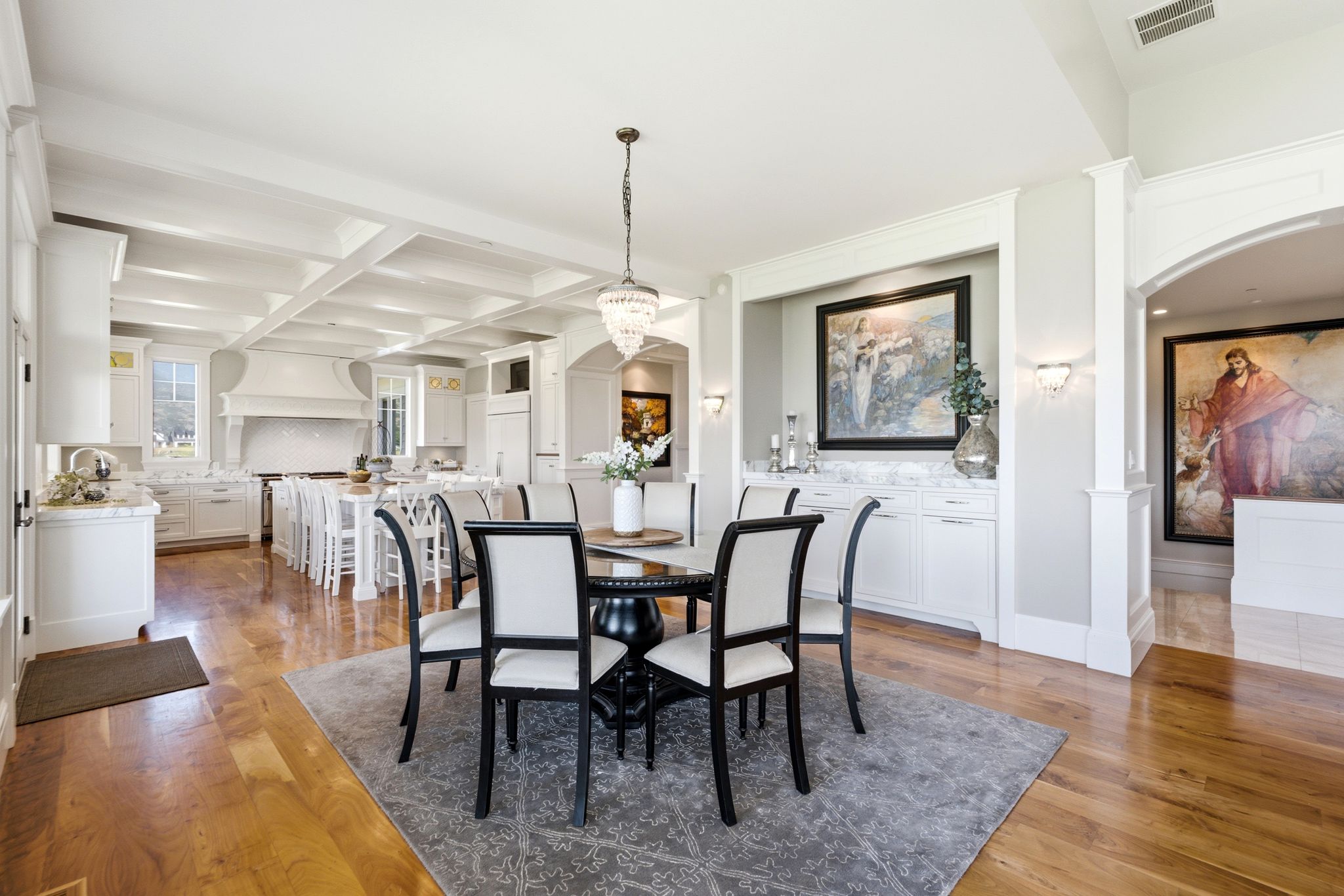 Formal dining area featuring a round pedestal table, upholstered chairs, and a detailed area rug