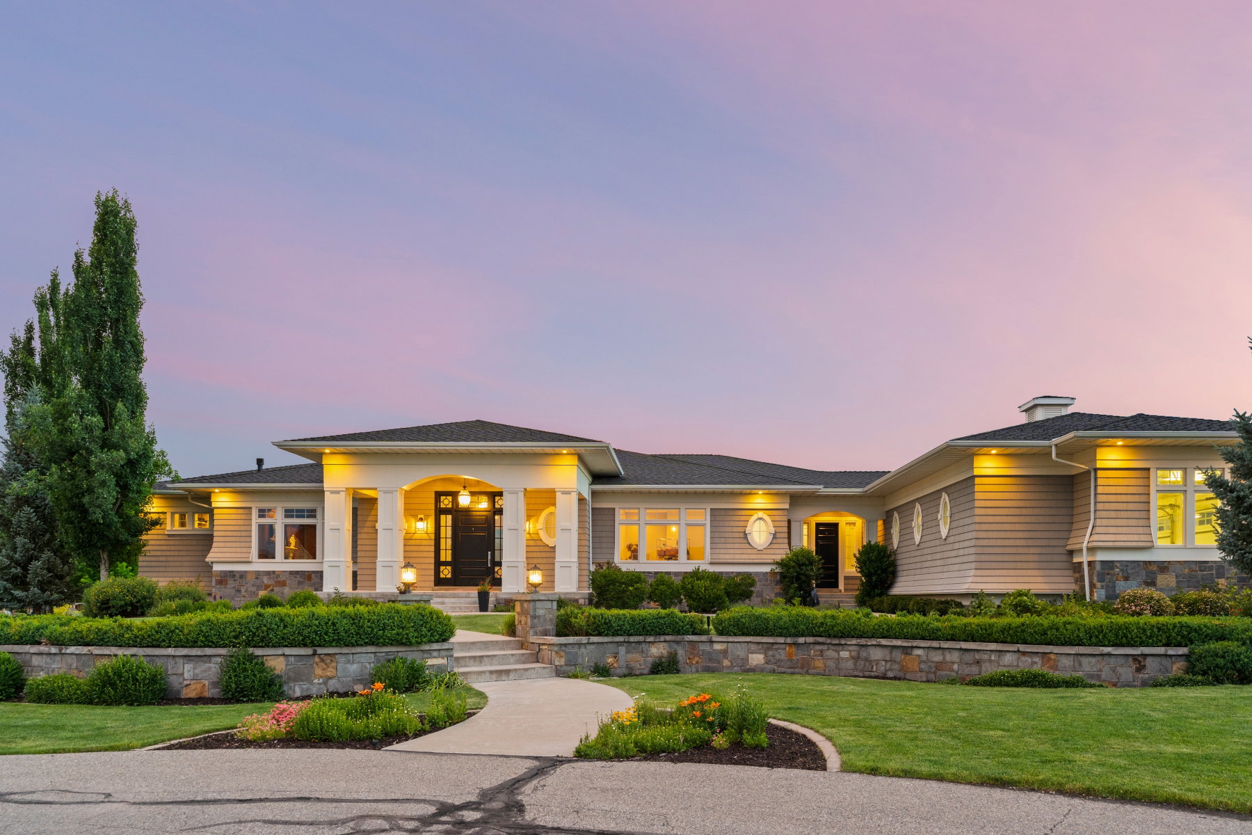Contemporary residence featuring a multi-gabled roofline and a stone foundation