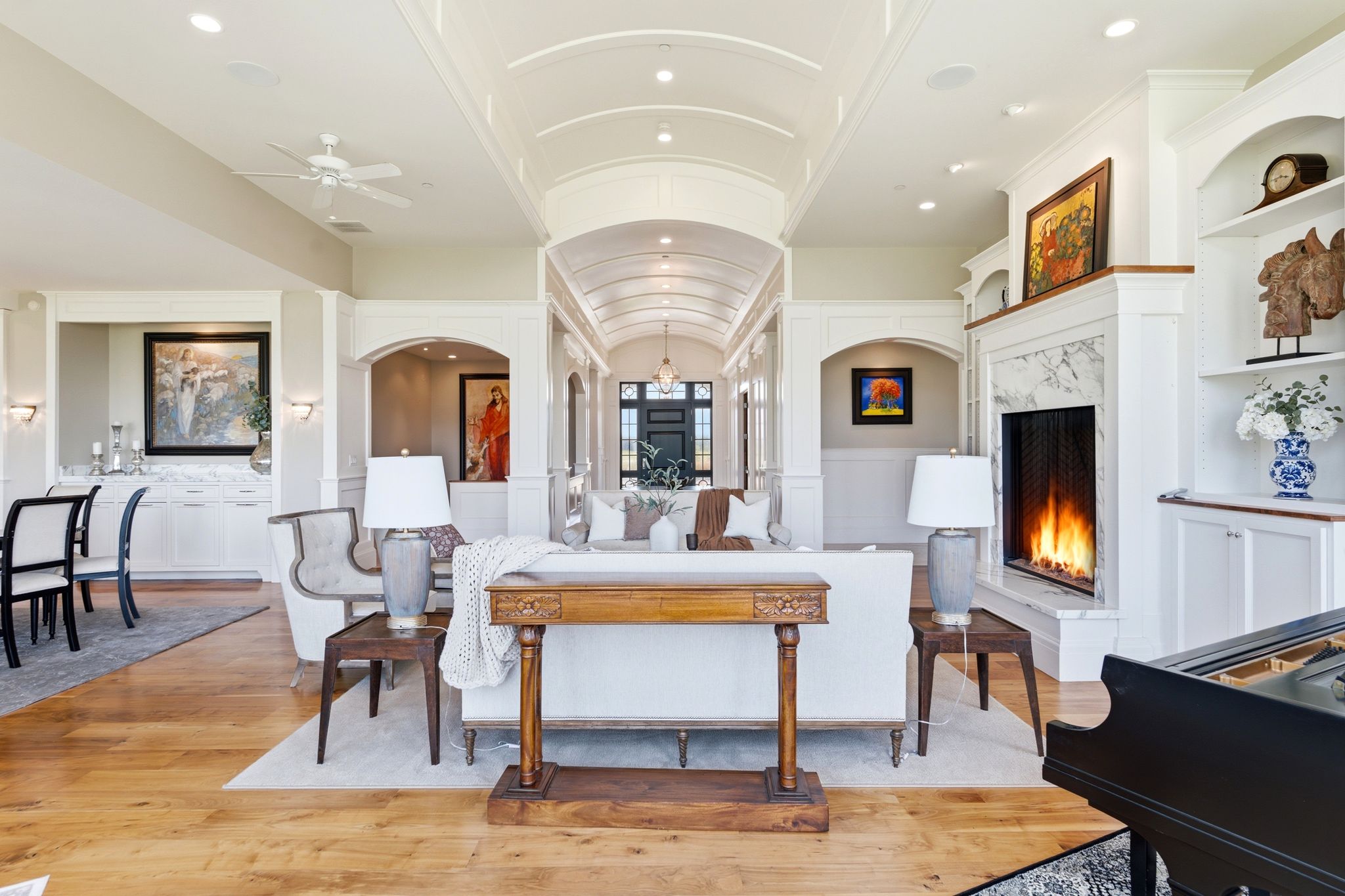 Spacious living area featuring light wood-finish flooring and a white tray ceiling