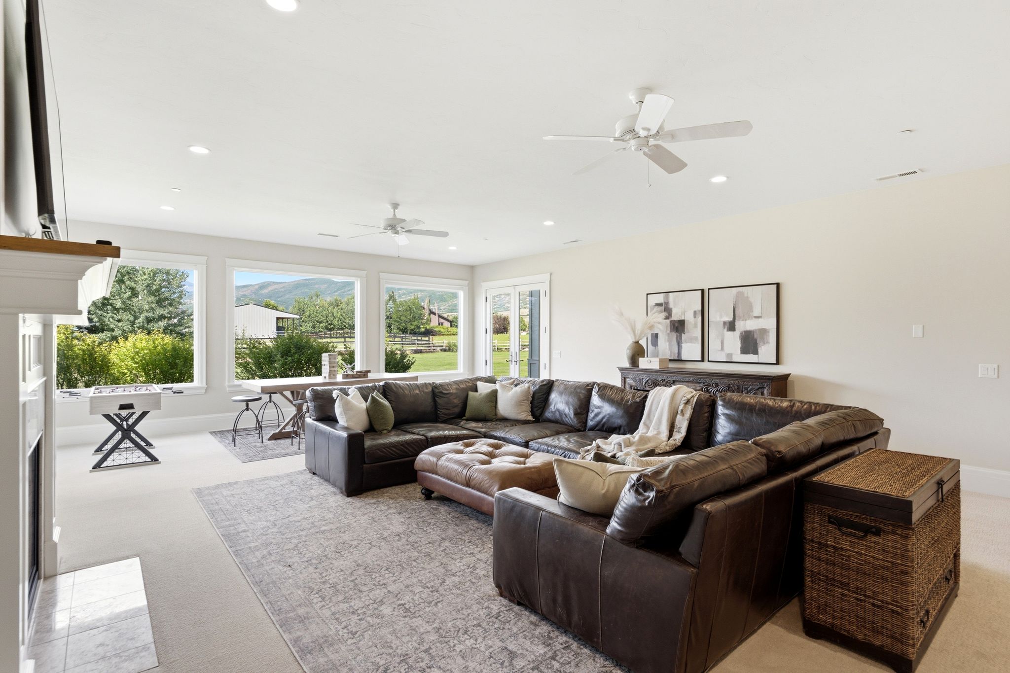 Spacious living area featuring expansive windows, recessed lighting, and ceiling fans